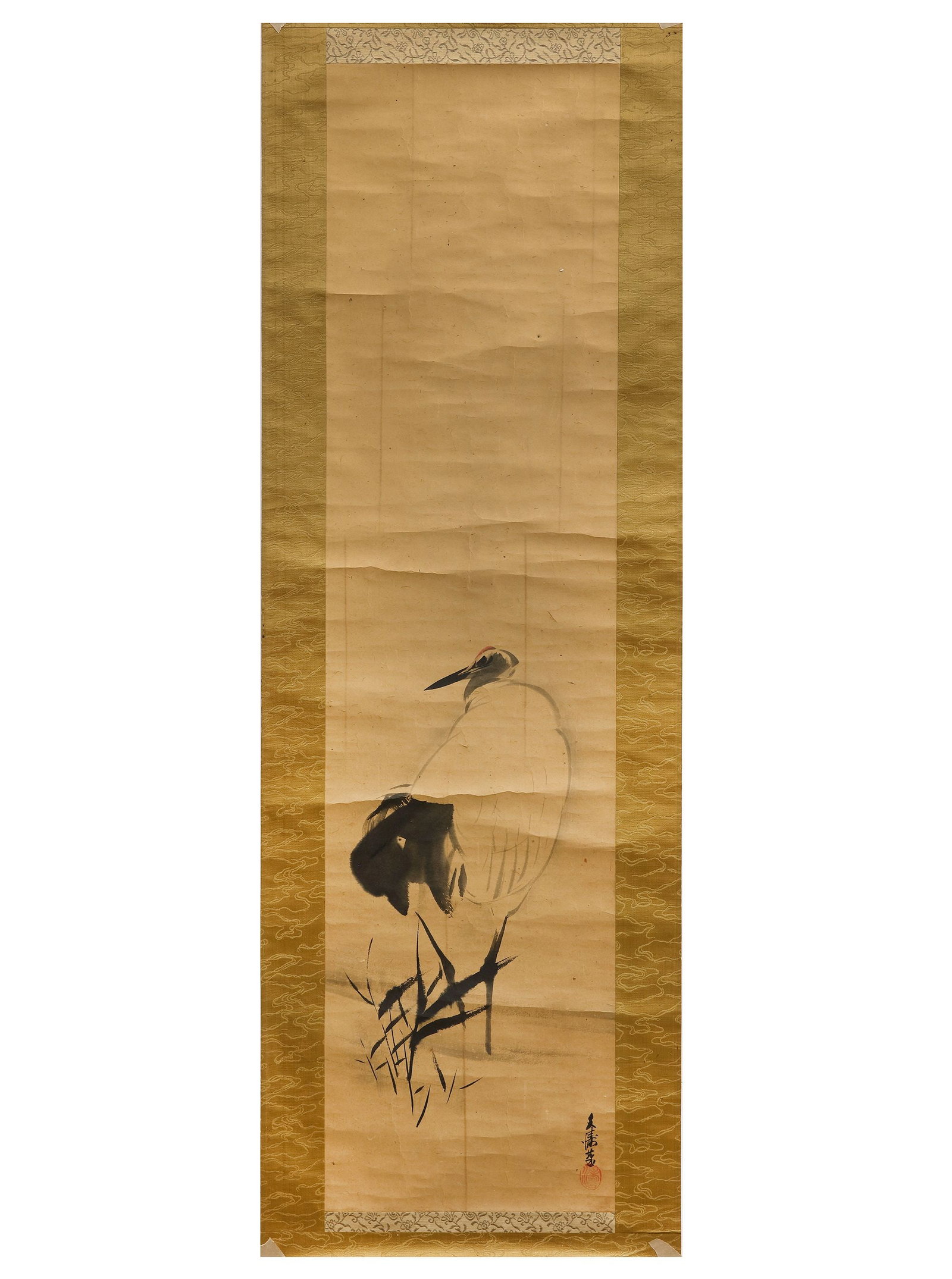 A JAPANESE SCROLL DEPICTING A CRANE, 19TH CENTURY: (Kach??-ga) A graceful Japanese hanging scroll depicting a solitary crane standing among reeds in a tranquil waterside setting. 130 by 44 cm. Vintage condition with age-related toning, folds, and wear