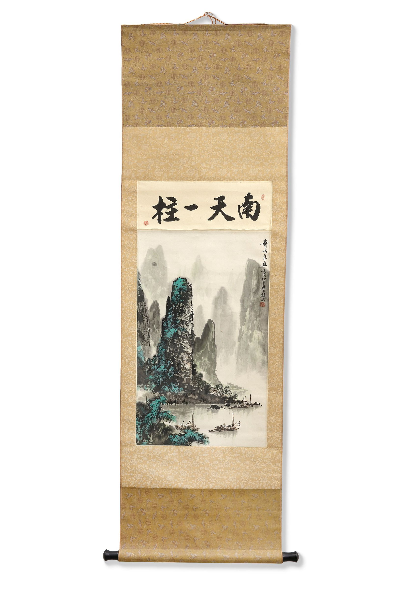 A MISTY MOUNTAIN RIVER LANDSCAPE, 20TH CENTURY: A Chinese hanging scroll painting depicting towering mountain peaks rising above tranquil waters and drifting mist. Small fishing boats glide across the river, while subtle blue-green accents add dept