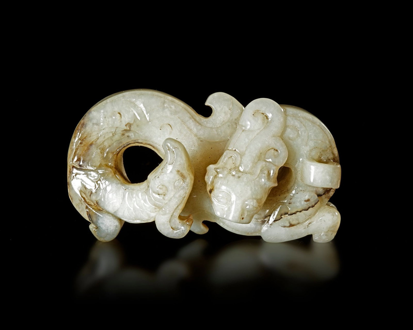 A WHITE JADE DRAGON/PHOENIX PENDANT, CHINA, HAN DYNASTY (206 BC-220 AD): 8 by 3,1 by 5 cm. PROVENANCE Purchased in 1996 from Mr. Frank H. Crane, a Canadian antique dealer. His shop, "The Hundred Antiques" was located in Stirling, Ontario, Canada.