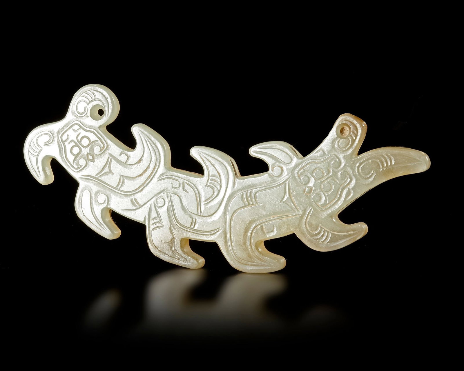 A WHITE JADE 'KUI' DRAGON PENDANT, CHINA, WESTERN ZHOU DYNASTY: Length 8,5 cm. PROVENANCE Purchased in 1996 from Mr. Frank H. Crane, a Canadian antique dealer. His shop, "The Hundred Antiques" was located in Stirling, Ontario, Canada.