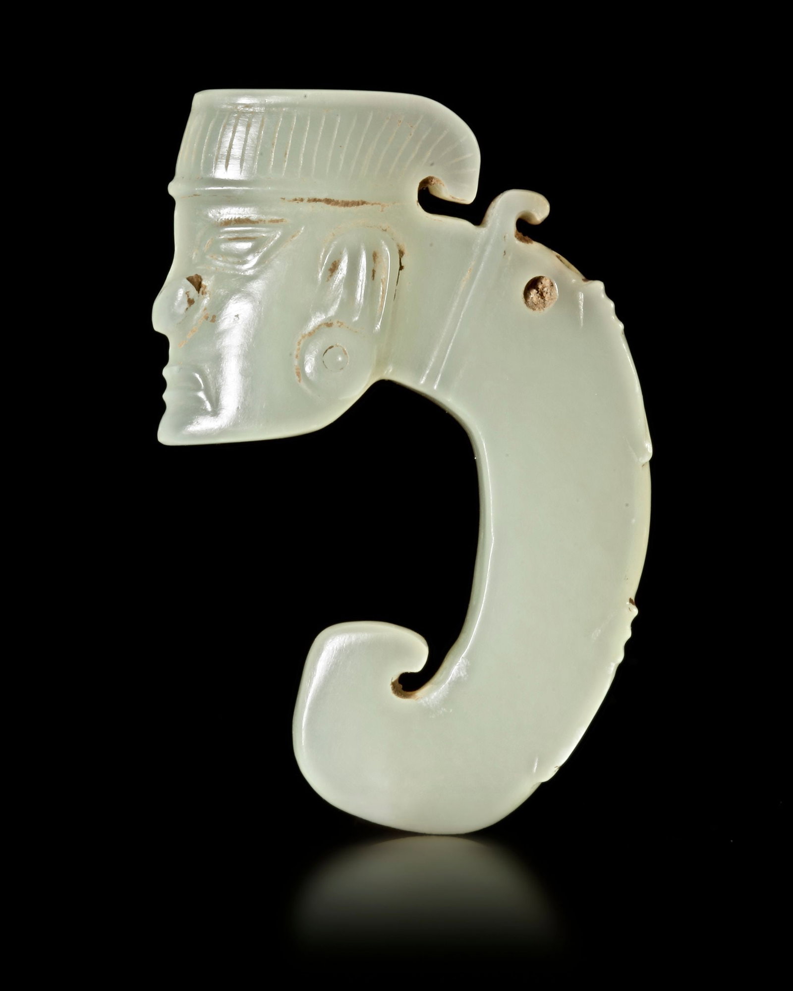 A WHITE JADE DRAGON PENDNT WITH A HUMAN HEAD, CHINA, SHANG DYNASTY: Height 6,5 cm. PROVENANCE Purchased in 1996 from Mr. Frank H. Crane, a Canadian antique dealer. His shop, "The Hundred Antiques" was located in Stirling, Ontario, Canada.