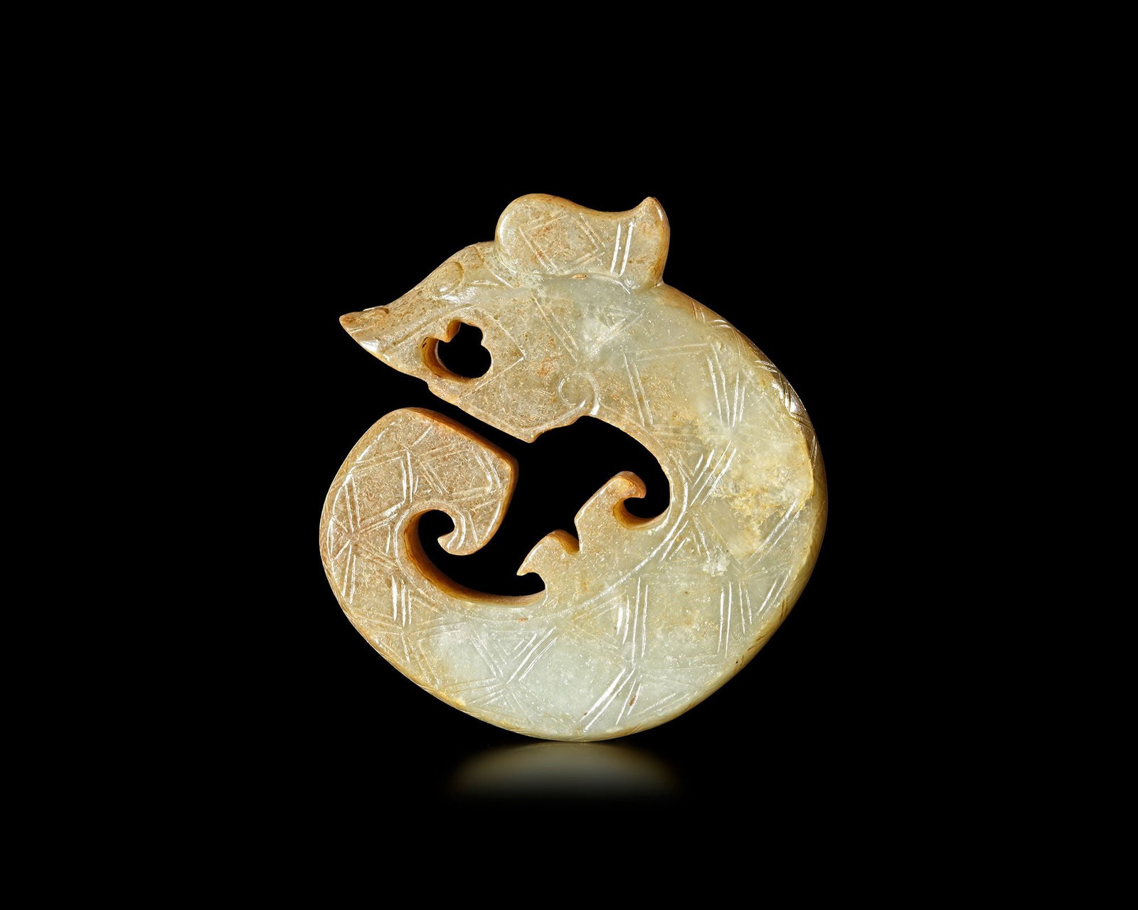 A YELLOWISH-GREEN JADE DRAGON, CHINA, SHANG DYNASTY: Diameter 6 cm. PROVENANCE Purchased in 1996 from Mr. Frank H. Crane, a Canadian antique dealer. His shop, "The Hundred Antiques" was located in Stirling, Ontario, Canada.