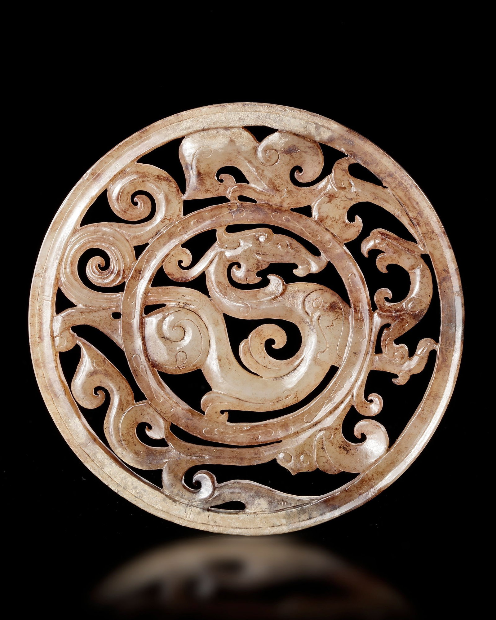 A DRAGON AND PHOENIX JADE BI, HAN DYNASTY (206 BCâ€“220 AD): A finely carved light green jade bi featuring intertwined dragon and phoenix motifs, symbols of power, harmony, and immortality in ancient China. Openwork scrolls and elegant curves reflect the except