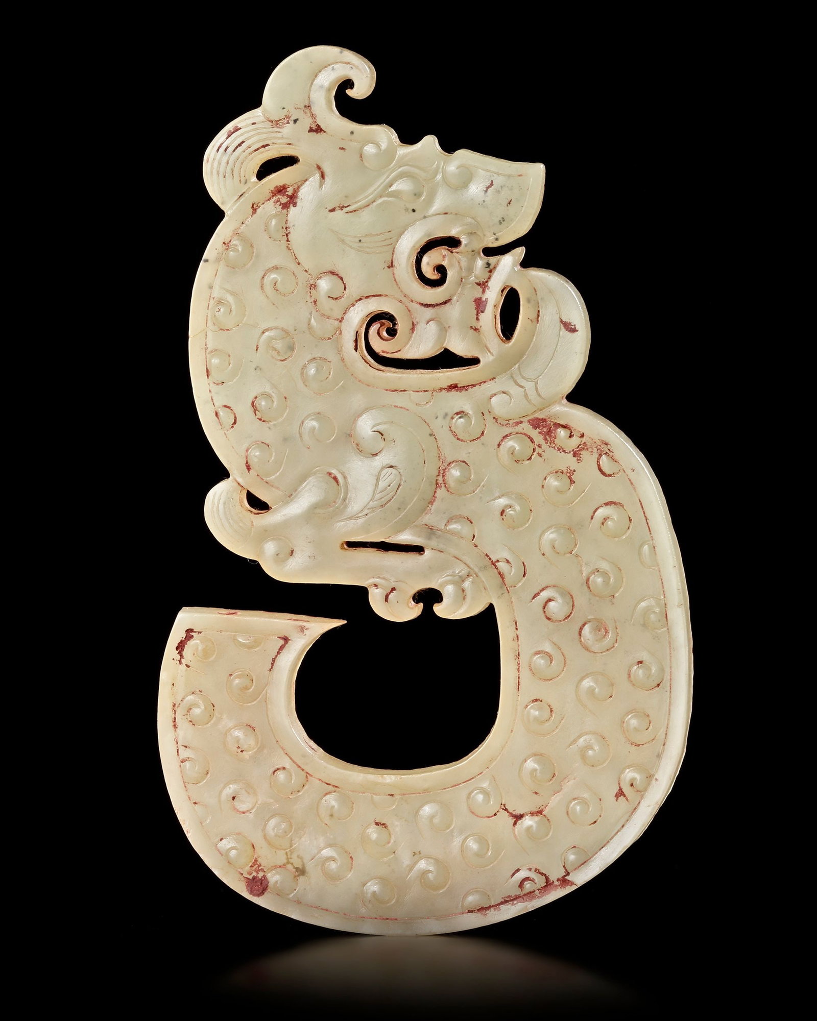 A CHINESE WHITE JADE DRAGON PENDANT, WESTERN HAN DYNASTY (206 BC-9 AD): An elegant white jade dragon pendant, finely carved with a powerful dragon head and a gracefully curved body adorned with raised spiral motifs. The openwork design and dynamic form symbolize strength,