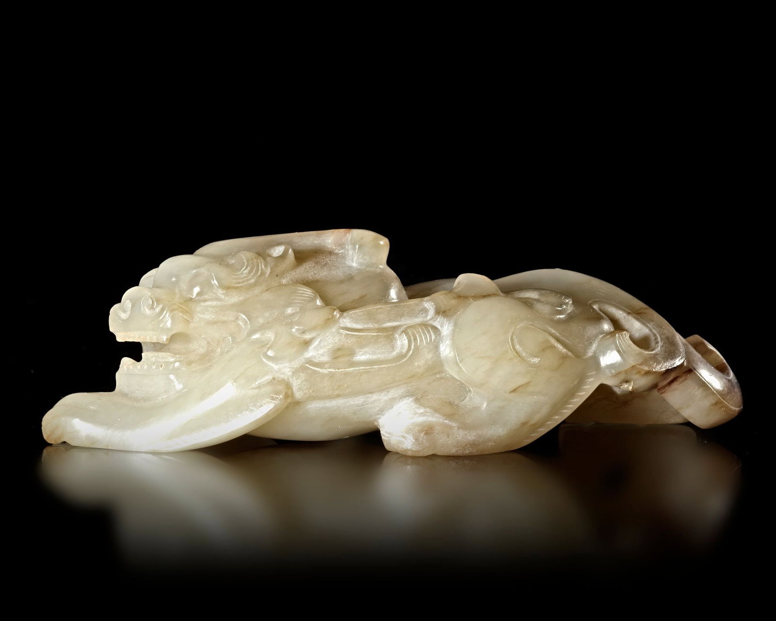 A CREAMY WHITE 'RUI SHOU' AUSPICIOUS BEAST, CHINA, HAN DYNASTY (206 BC-220 AD): 9 by 4,3 by 2,6 cm. PROVENANCE Purchased in 1996 from Mr. Frank H. Crane, a Canadian antique dealer. His shop, "The Hundred Antiques" was located in Stirling, Ontario, Canada.