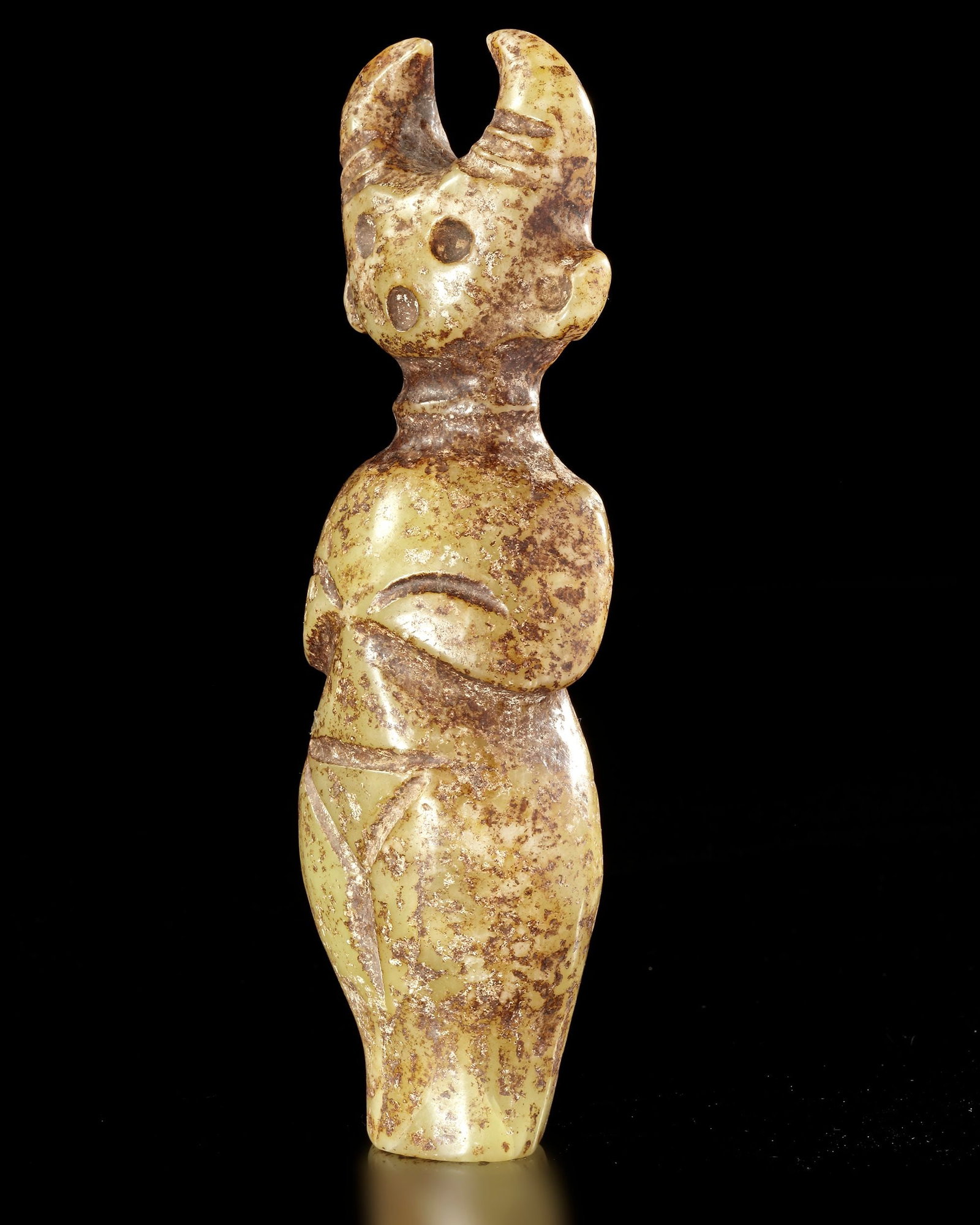 A GREENISH-YELLOW JADE CARVING OF A HORNED STANDING FIGURE, CHINA, HONGSHAN CULTURE: 17 cm. PROVENANCE Purchased in 1996 from Mr. Frank H. Crane, a Canadian antique dealer. His shop, "The Hundred Antiques" was located in Stirling, Ontario, Canada.