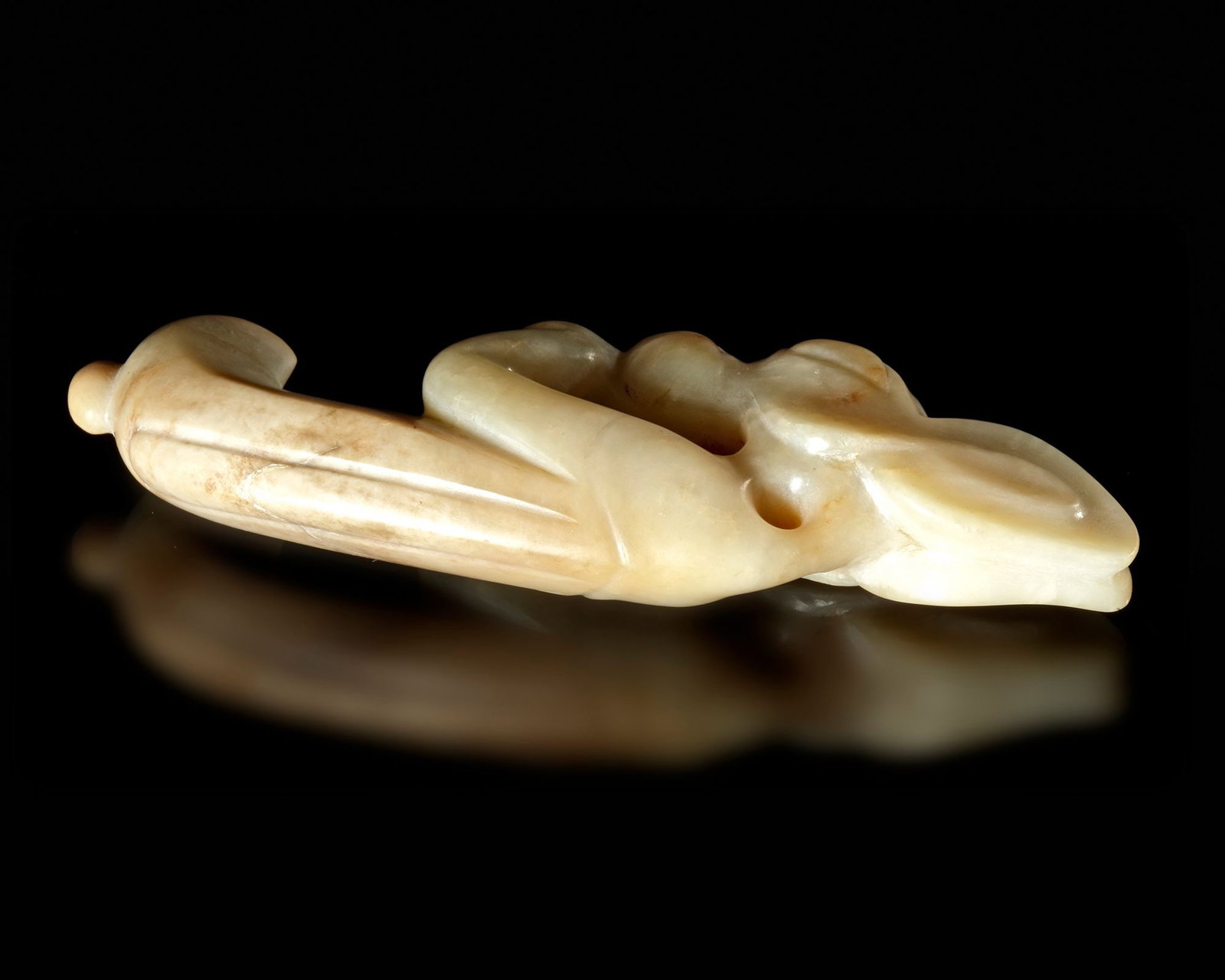 A CREAMY WHITE JADE CARVING OF AN EMBRYONIC MYTHICAL ANIMAL, CHINA, HONGSHAN CULTURE: Height 9.5 cm. PROVENANCE Purchased in 1996 from Mr. Frank H. Crane, a Canadian antique dealer. His shop, "The Hundred Antiques" was located in Stirling, Ontario, Canada. Reference: â€?Archaic J