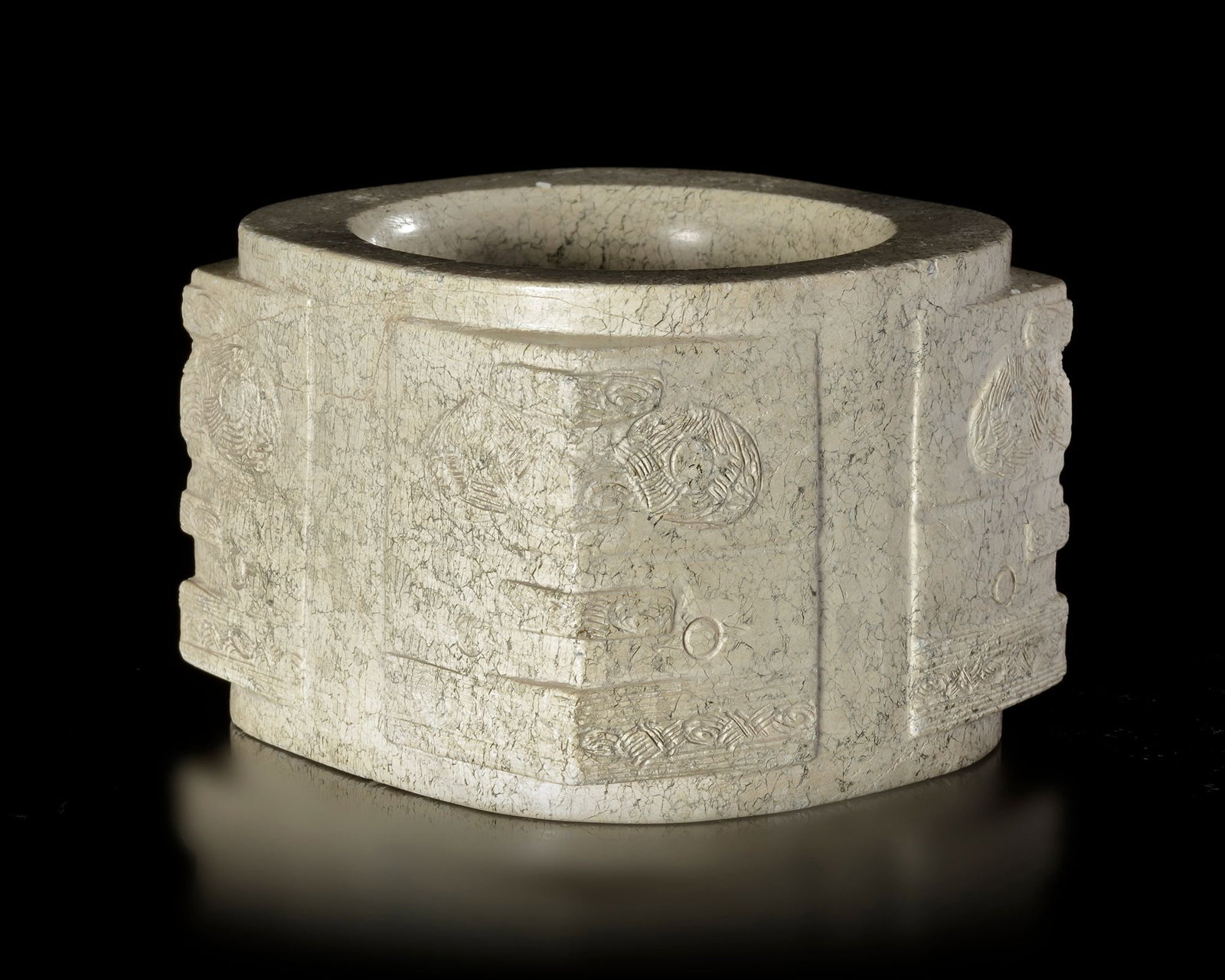 A BEIGE-COLORED JADE CONG WITH RUST-LIKE BROWN INCLUSIONS DECORATED WITH TWO TIERS OF FACES, CHINA,: 7.6 cm by 7.4 cm by 5.4 cm. PROVENANCE Purchased in 1996 from Mr. Frank H. Crane, a Canadian antique dealer. His shop, "The Hundred Antiques" was located in Stirling, Ontario, Canada.