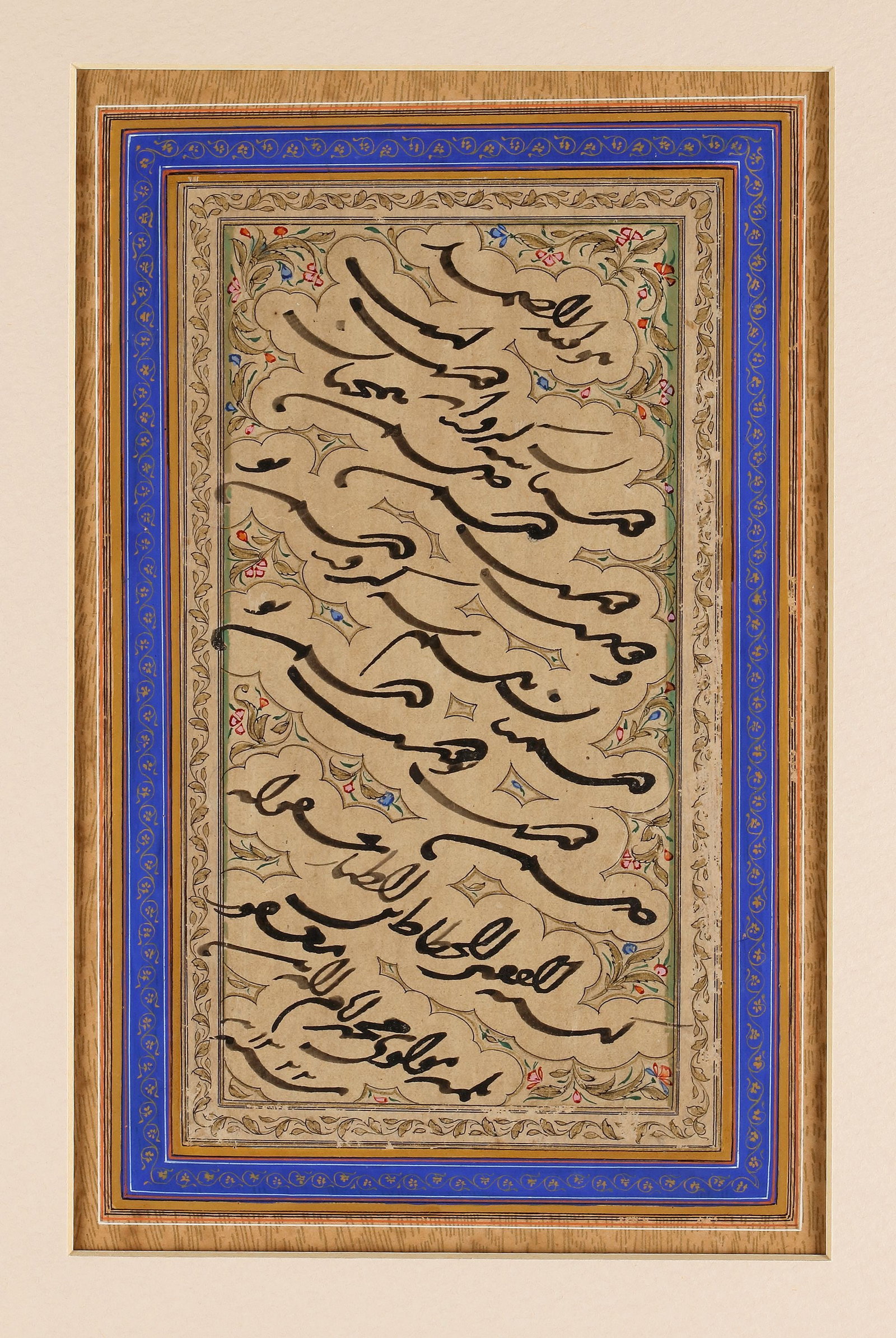 AN OTTOMAN CALLIGRAPHIC PANEL, TURKEY AND DATED 1322 AH/1904 AD: Arabic manuscript on paper, 7 lines, written diagonally in black naskh script, set within cloud bands reserved against a gilt ground, adorned with gilt and polychrome floral scrolls. Ruled with black 