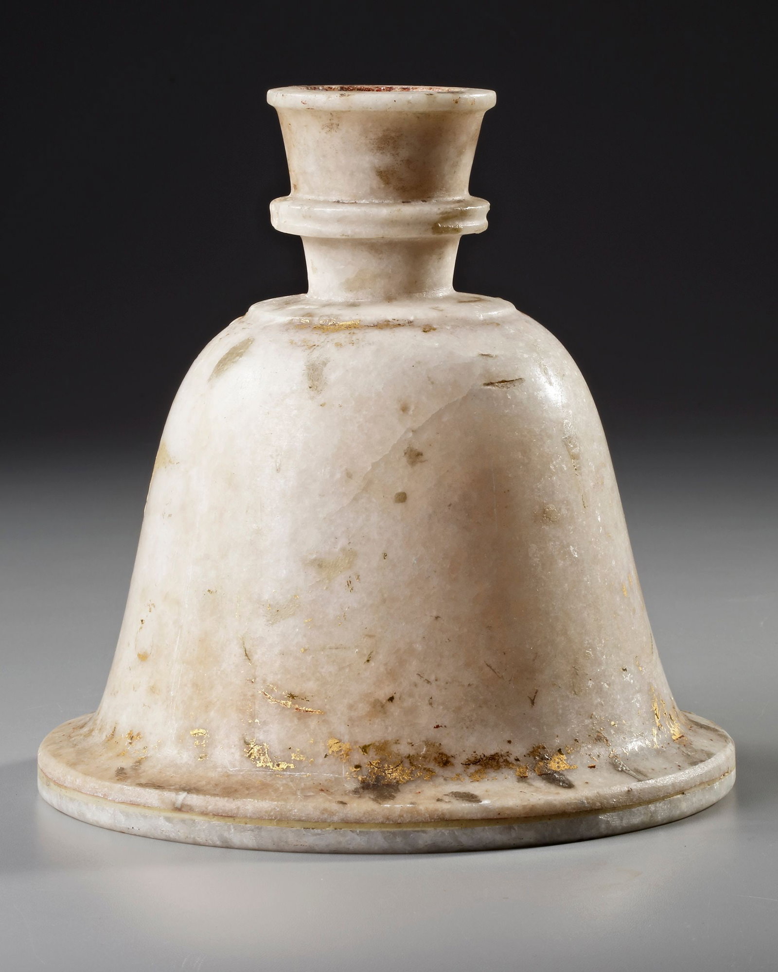 AN INDIAN ALABASTER HOOKAH BASE, 18TH CENTURY: An Indian bell-shaped alabaster hookah base. Carved from smooth, veined alabaster, it features a wide, stable foundation and a rounded opening at the top for the hookah body. Subtle traces of gilding 