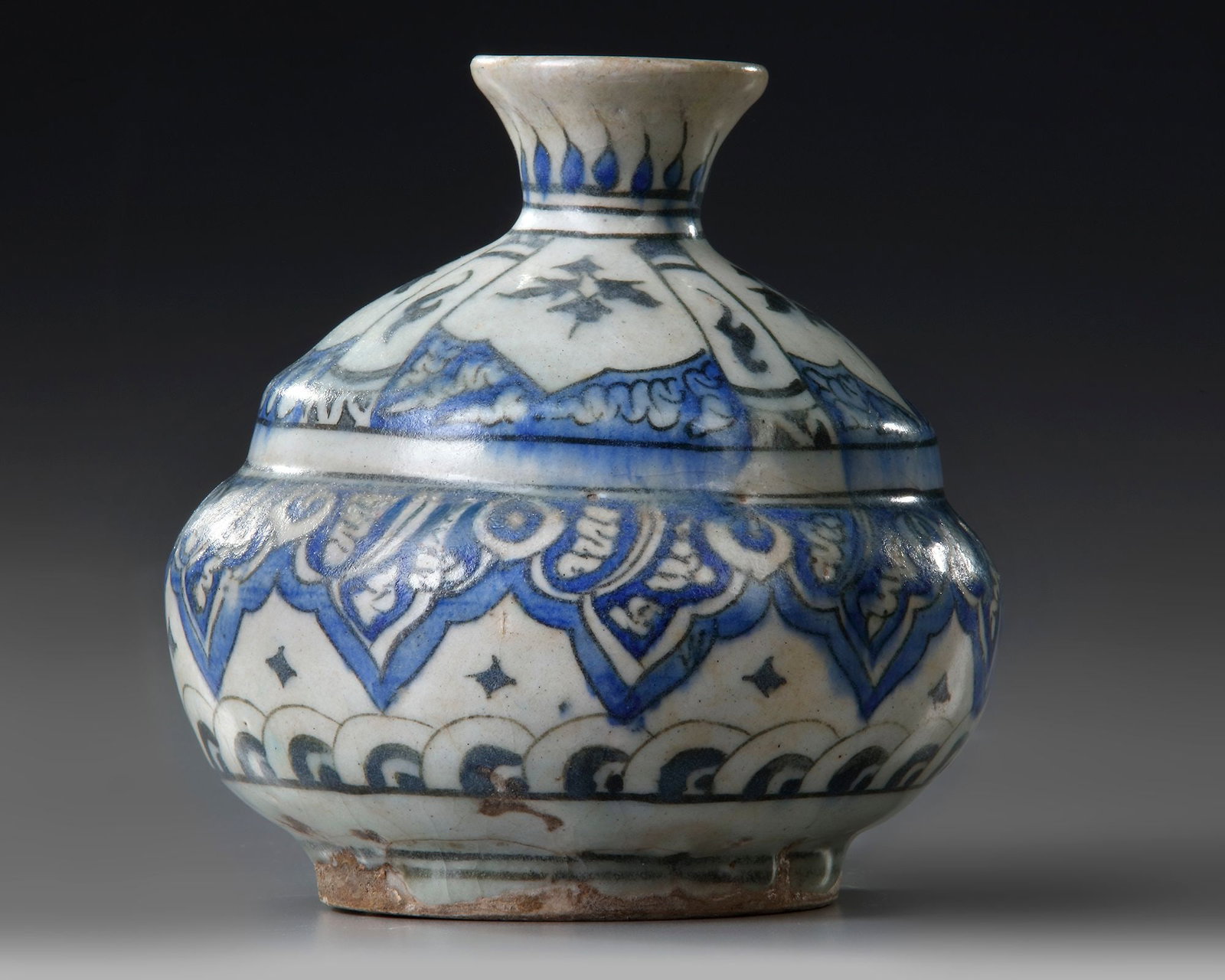 A PERSIAN QAJAR VASE, PERSIA, 18TH-19TH CENTURY: A Persian double gourd vase with small flaring mouth, decorated in cobalt blue and black with floral leafy sprays, the base with sea waves and leaves to the neck. Height 13 cm. Diameter 13 cm.
