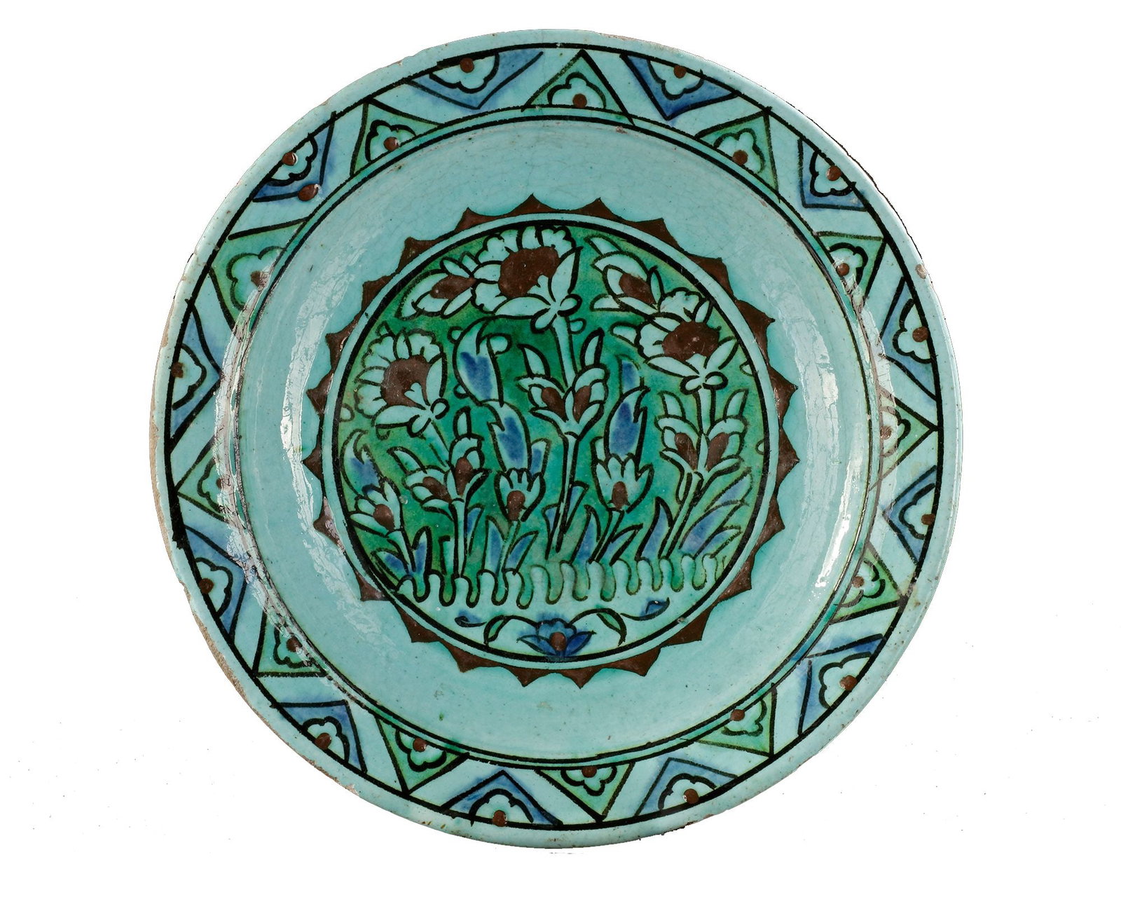AN OTTOMAN IZNIK POTTERY PLATE, 17TH CENTURY: A finely painted Iznik ceramic plate from the 17th century, decorated in vibrant turquoise, cobalt blue, and green. The central field features stylized floral motifsâ€”evoking tulips and g