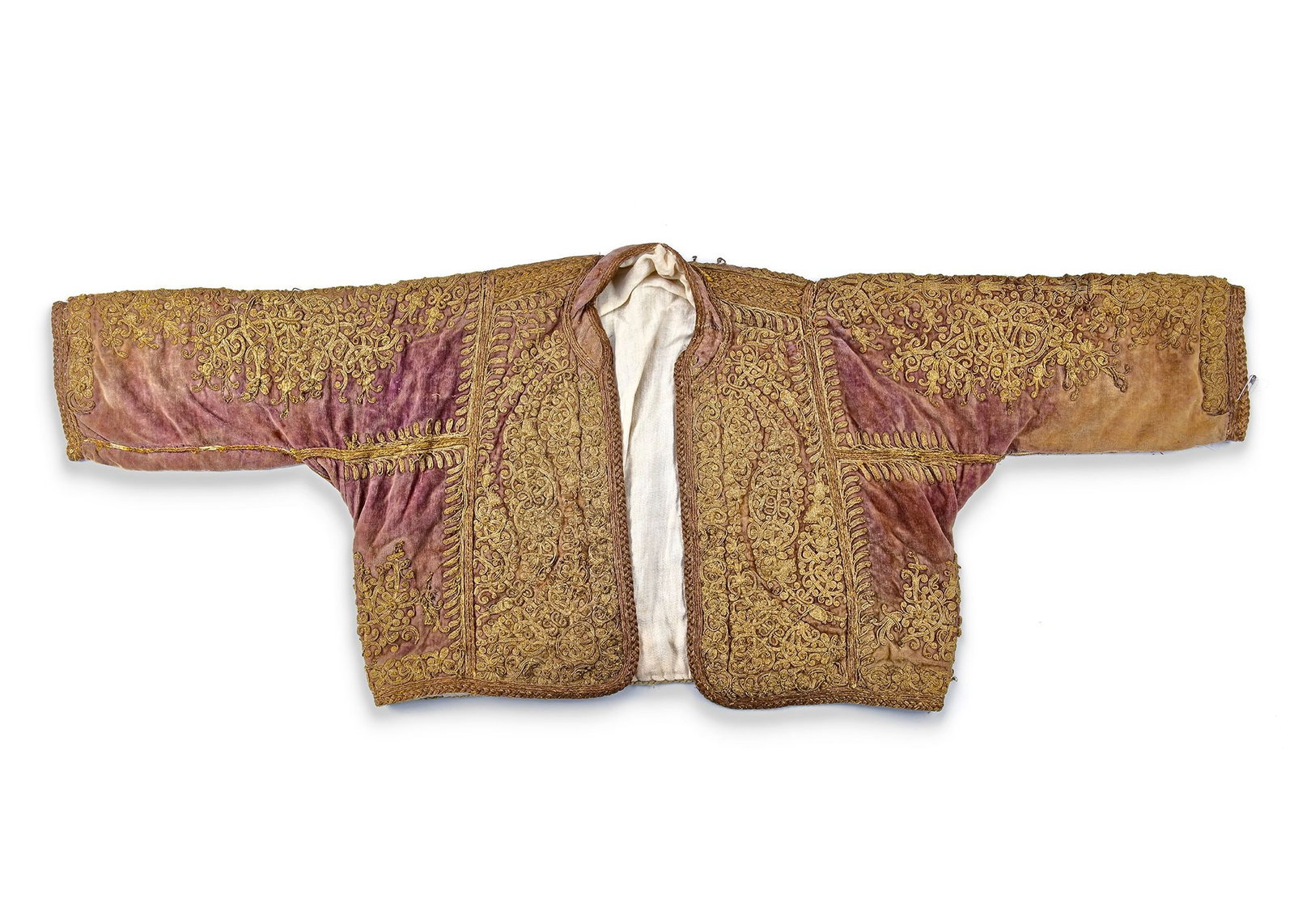 A FINE EMBROIDERED OTTOMAN METALLIC THREAD JACKET, TURKEY 18TH-19TH CENTURY: A finely tailored, hip-length Ottoman jacket of rose-toned velvet, richly embroidered in dense metallic thread. The surface is almost entirely covered with symmetrical scrolling arabesques and stylize