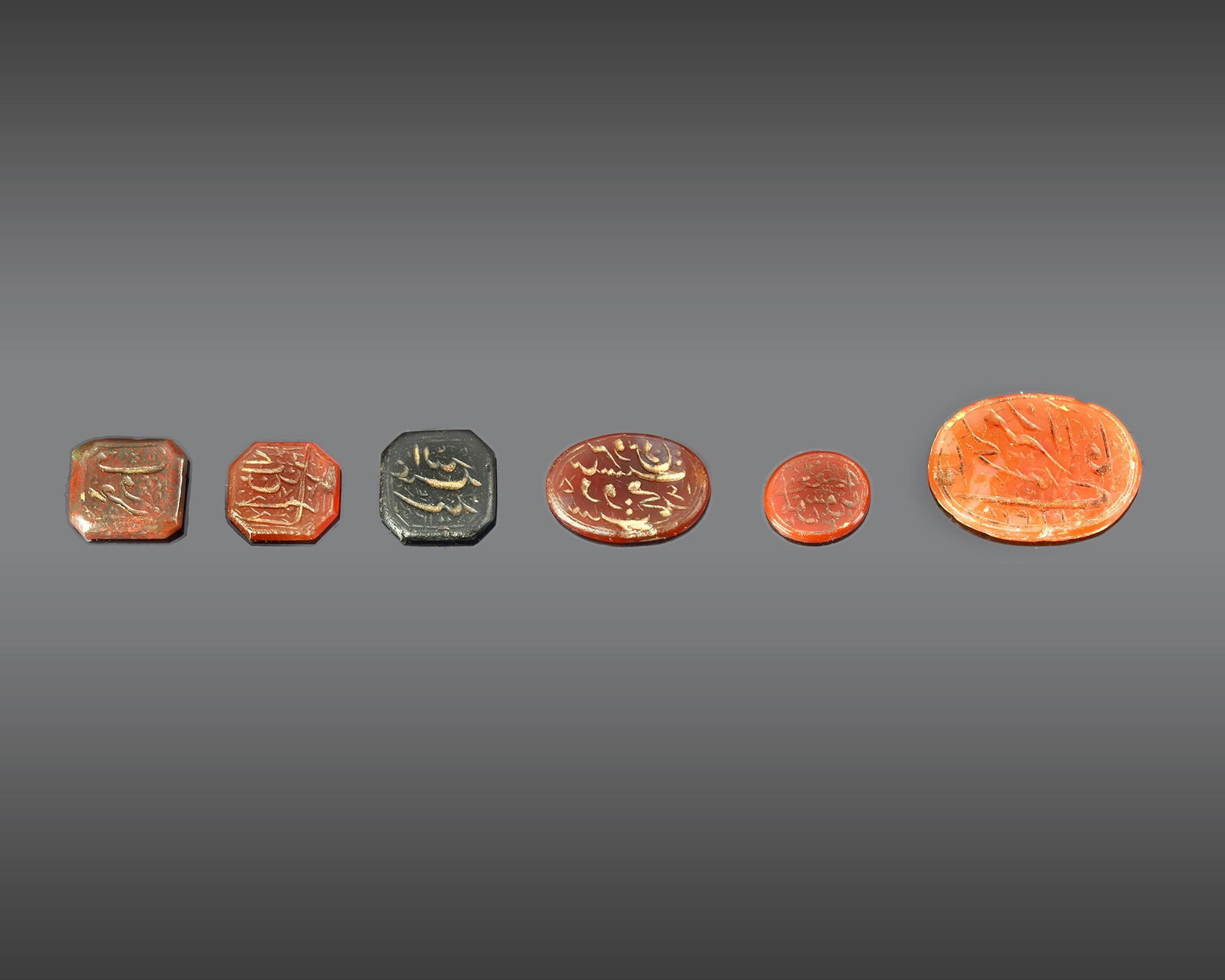 A GROUP OF SIX QAJAR AGATE SEALS, PERSIA 19TH CENTURY: Each carved with inscriptions in nastaliq script. Largest: 22 mm Smallest: 10 mm