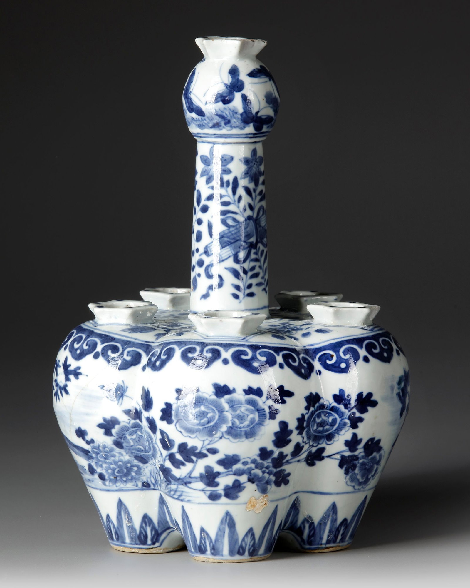 A CHINESE BLUE AND WHITE TULIP-SHAPED VASE, 19TH CENTURY: Of distinctive bulbous, tulip-shaped form, finely painted in underglaze cobalt-blue with flowering peonies, bamboo, rocks and foliage, the rounded body encircled by a band of ruyi heads and stylised p