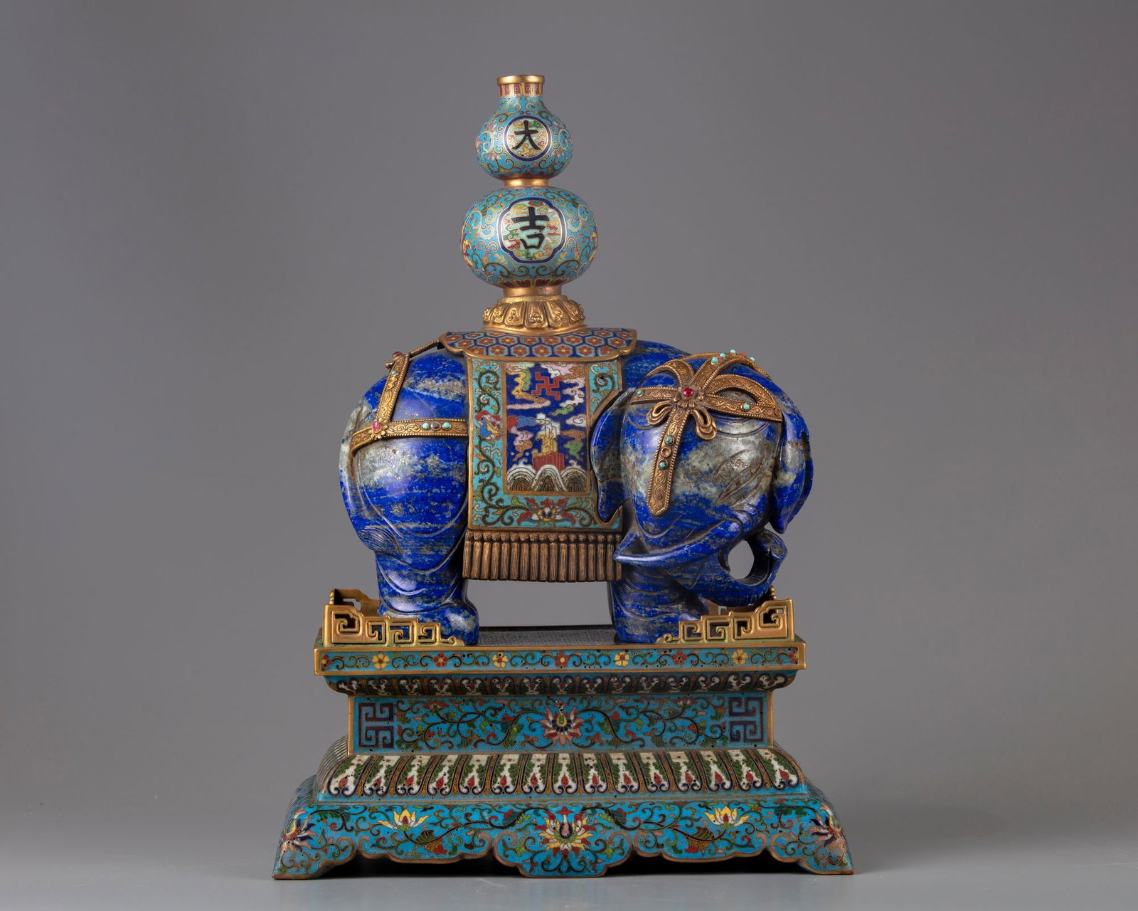 A LAPIS LAZULI CARVING OF AN ELEPHANT WITH CLOISONNE MOUNTS ON A STAND, 19TH CENTURY (1 of 7)