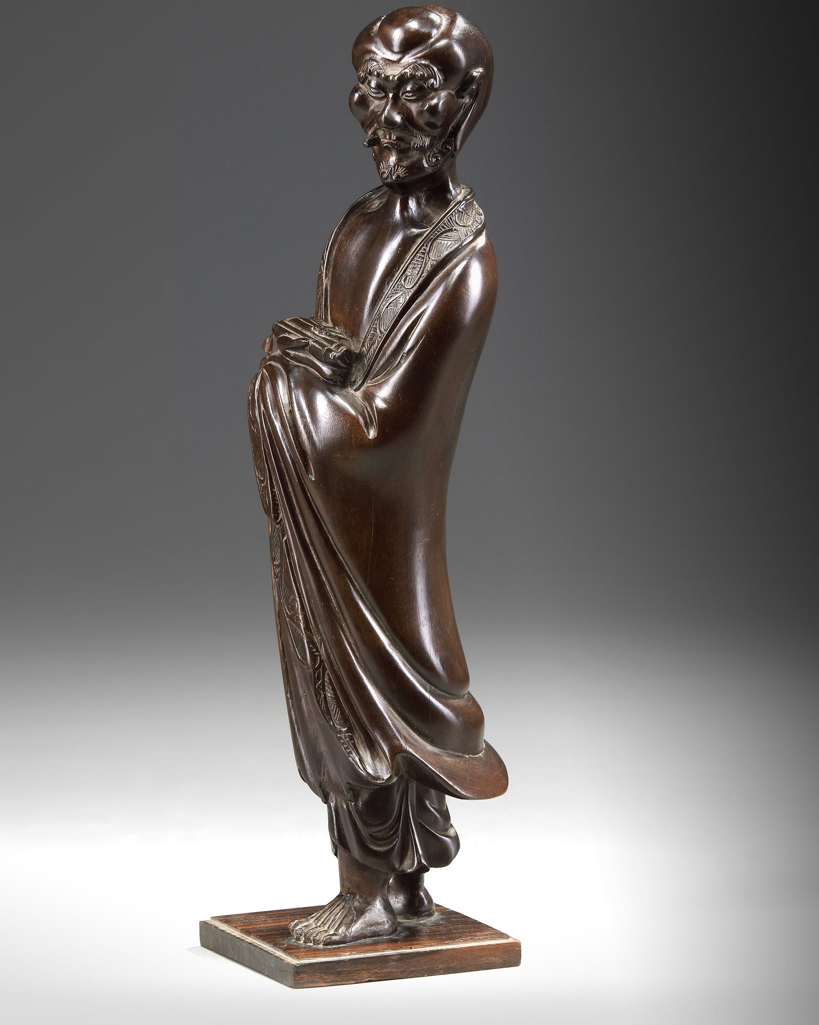 A CHINESE HARDWOOD CARVING OF LUOHAN HOLDING A SCROLL (1 of 4)