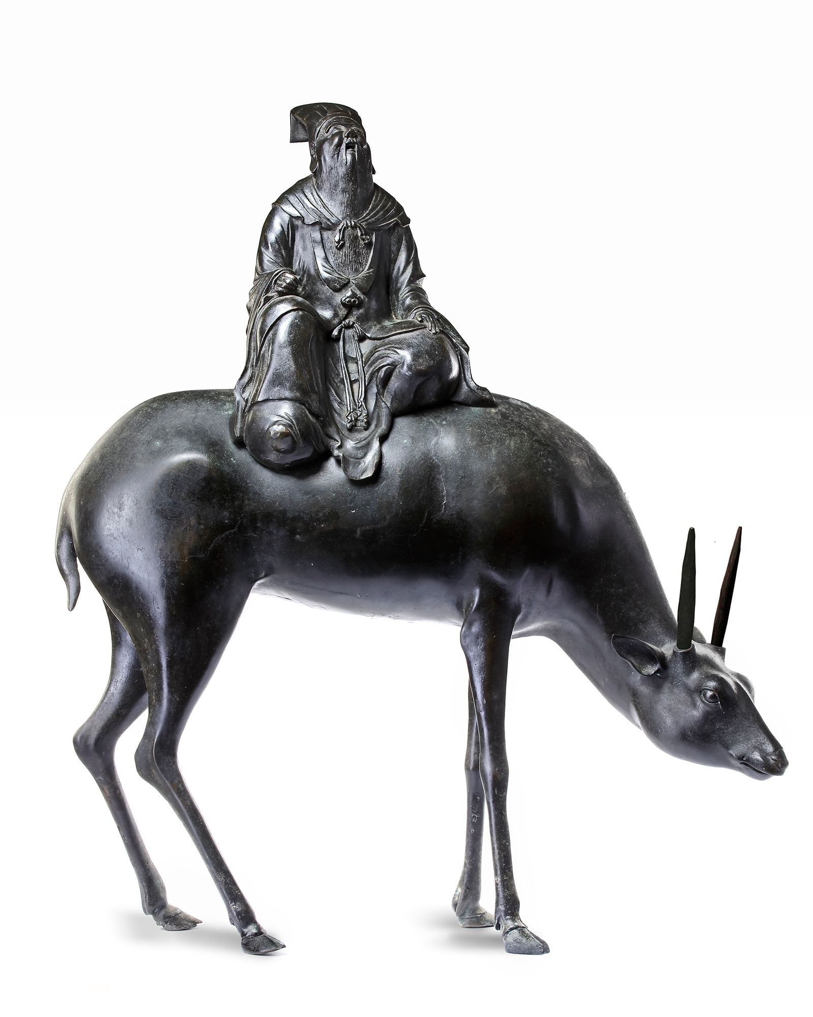 A LARGE CHINESE BRONZE CENSER MODELLED AS A DIGNITARY RIDING A DEER, MING DYNASTY (1368-1644): A bronze two part censer in the form of a dignitary seated on a deer. The figure wearing a long decorative robe, tall hat, seated on a harnessed deer with its head lowered and turned to one side. 85 b