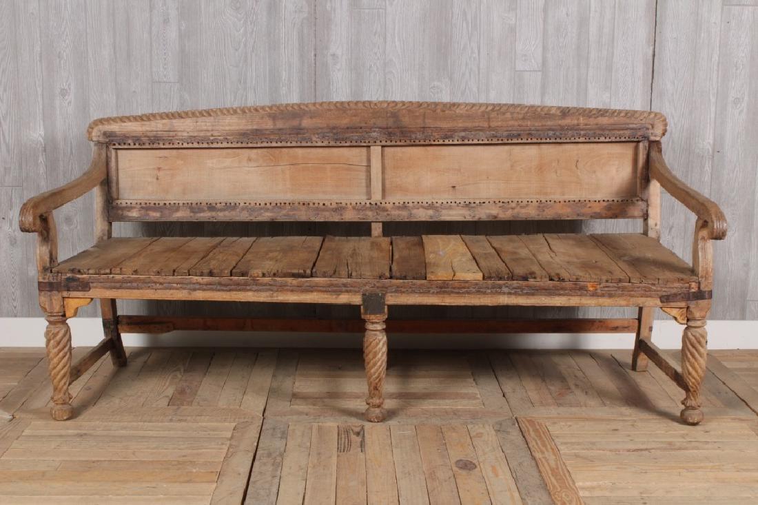 Plantation Style Bench: A bleached wood garden bench having carved crest rail over paneled back and open arms. Size: 37" x 76" x 28"