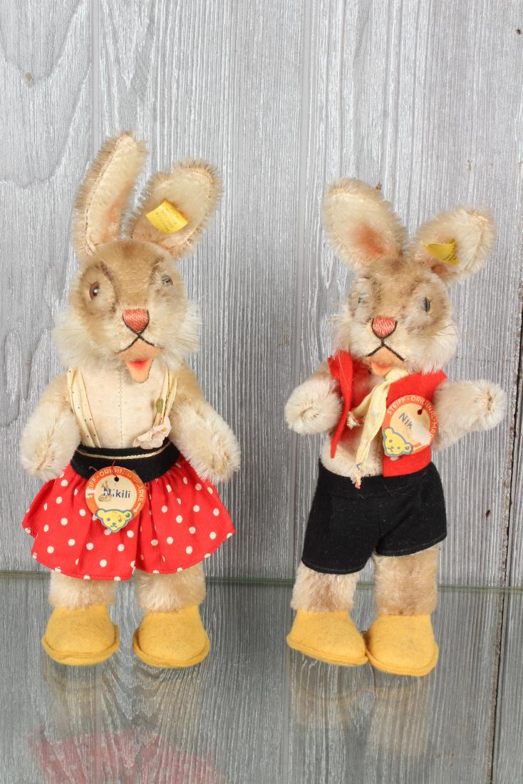 Pair of Steiff Nikili Hare Figurines: Pair of Steiff Nikili Hare Figurines. VIntage mohair, open mouths, with chest labels and button and tags in ears. 8726.70 and 8726.80. Size largest 10 3/4" x 4 1/4" x 2 1/2"