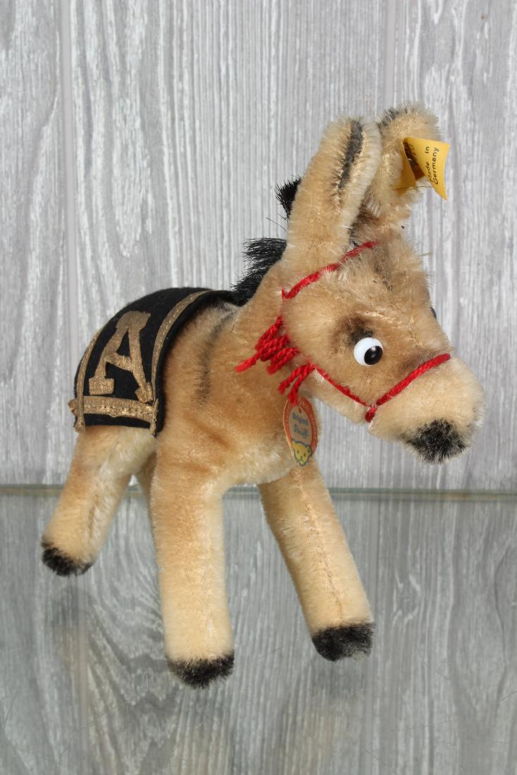 Vintage Steiff Army Mule: Vintage Steiff Army Mule. Army mascot mule/donkey with felt blanket and letter A on either side. Mohair, cord tail, glass eyes, with chest label and button and tag in ear. 1314,0. Size 6 1/2" x 6" x 2