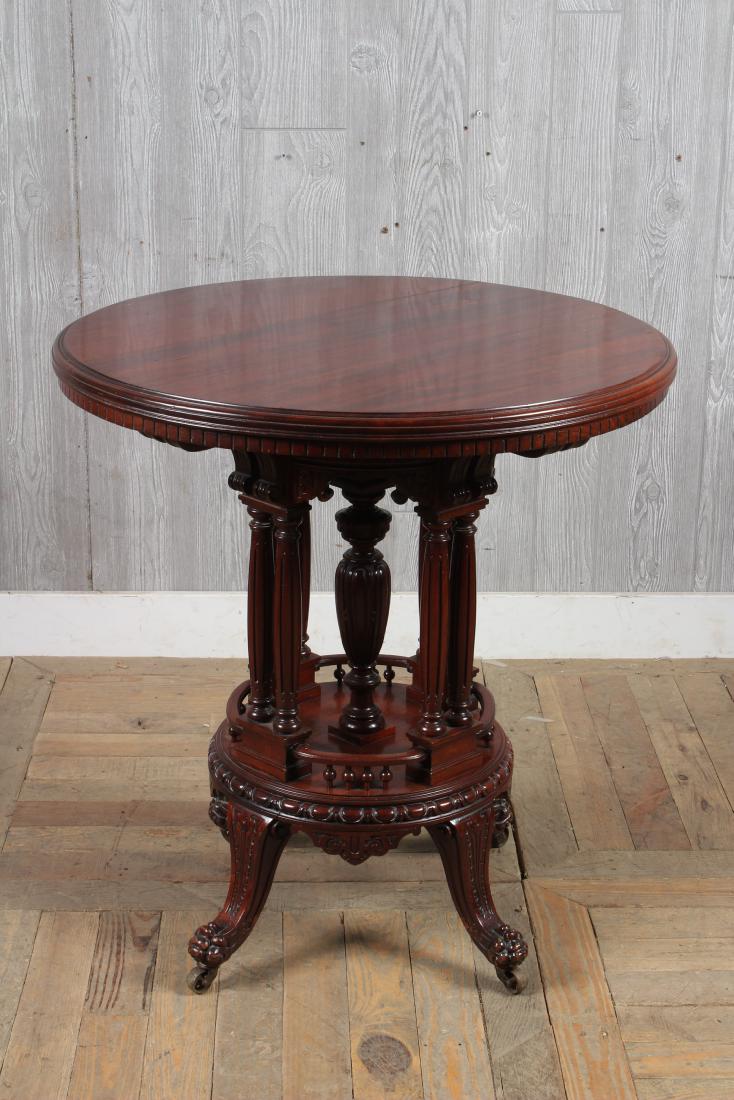 Victorian Carved Center Table: A turn of the century mahogany center table with carved apron over turned posts and paw feet. Size: 30" H x 28" W x 28" D