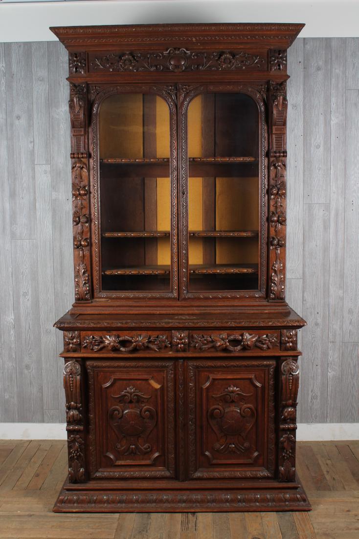 Victorian Oak Bookcase: A very good Victorian late 19th C. carved oak bookcase, having a carved cornice over 2 glass panel doors flanked by griffins over a lower case with floral and leaf carved drawers and doors. Size: 93.5