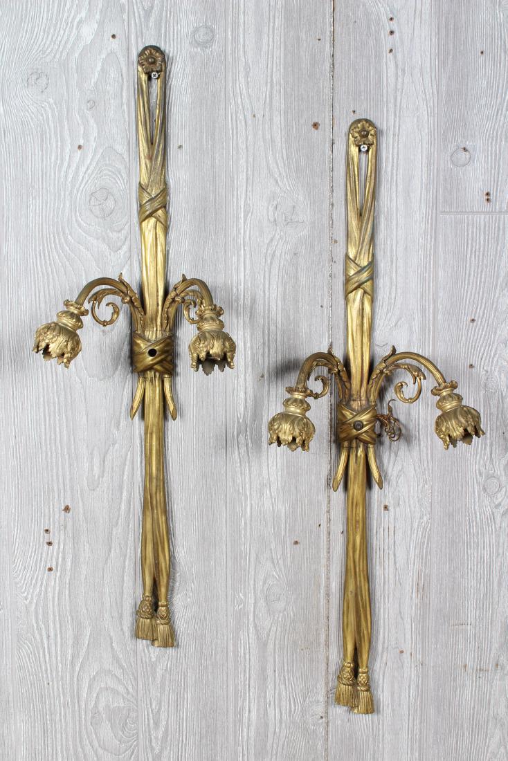 Pair Gilt Bronze Sconces: A pair of gilt bronze sconces in the French taste. Size: 30" H x 9.5" W x 5" D