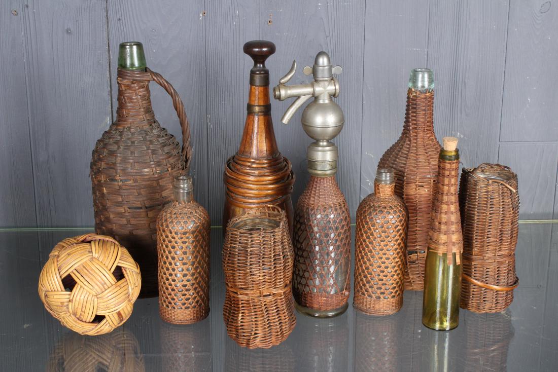 9 Piece Lot Wicker Wrapped Bottles: 9 Piece Lot Wicker Wrapped Bottles. Clear and colored glass bottles, one with dispenser. Size: Largest: 13" H x 5" W x 5" D