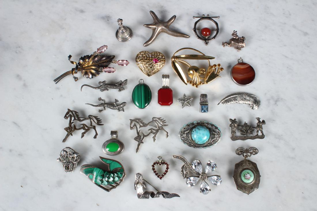 26 Sterling Silver Pendants and Brooches: 26 Sterling Silver Pendants and Brooches. Includes two lizard brooches, two horse brooches, feather, star, floral basket, frog, mermaid, locket with enameled medallion, Mexican Fish with green malachi