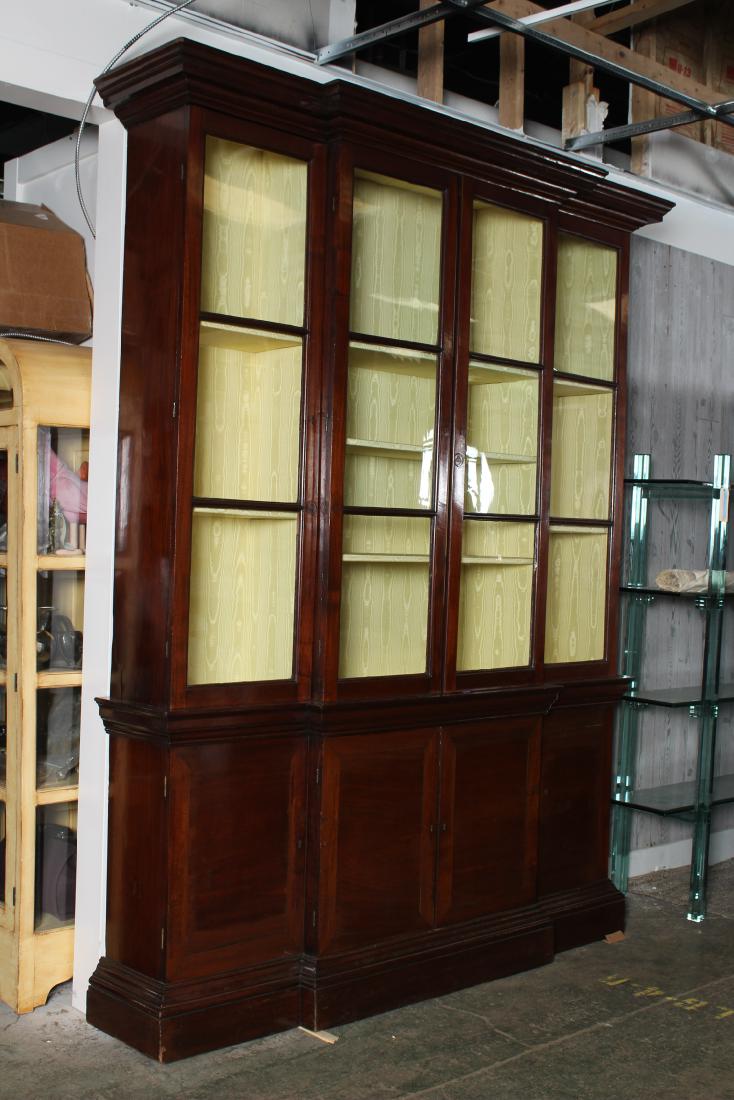 Georgian Mahogany Breakfront: An English George III elegant breakfront having a stepped cornice over glazed and mullioned doors above paneled doors. Size: 101" H x 76" W x 16" D