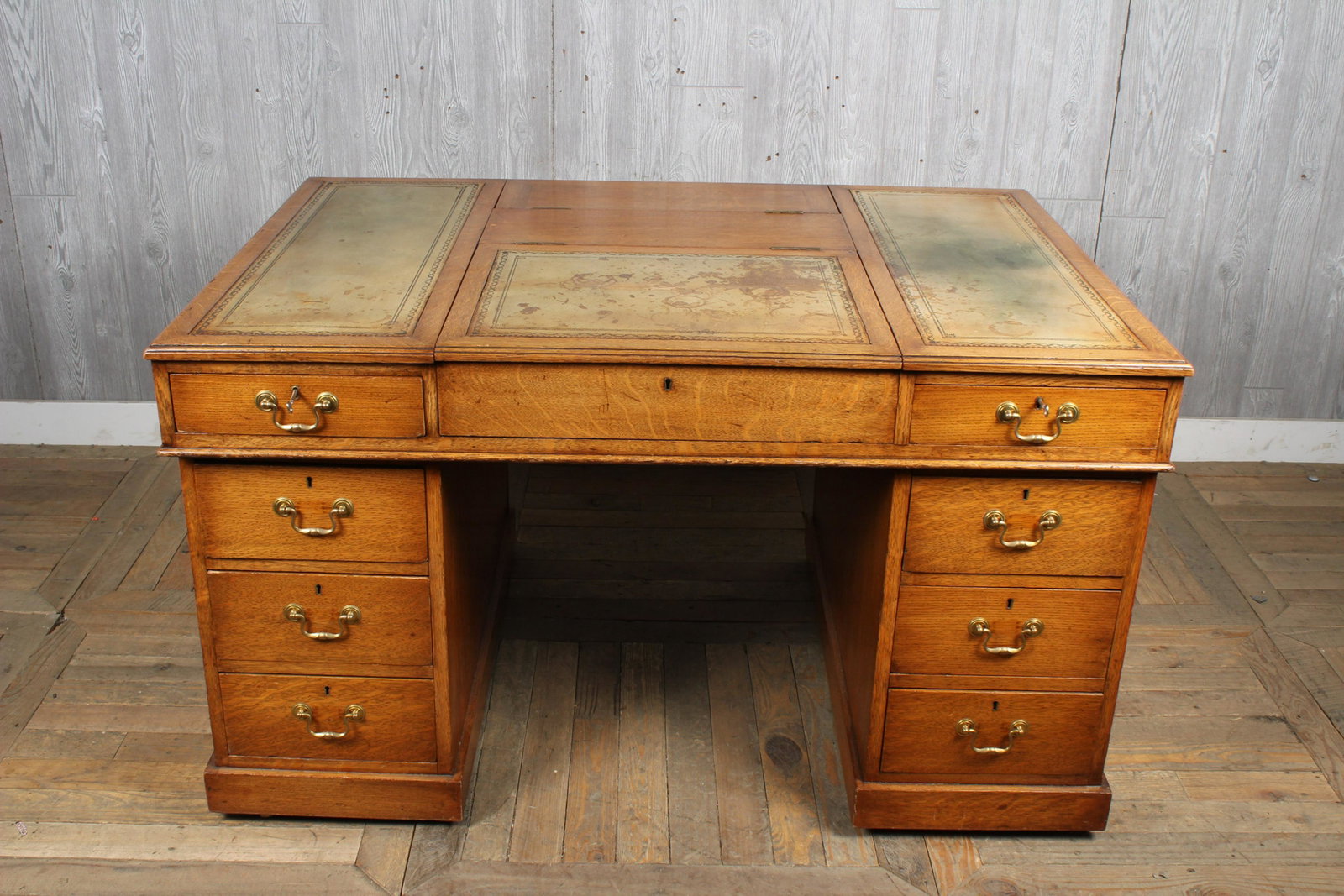 Partner: Partner's Desk with Tooled Leather, writing surface, center lift top drawer flanked by four drawers on either side, partner's side of desk with center lift top drawer flanked by cabinet door on either