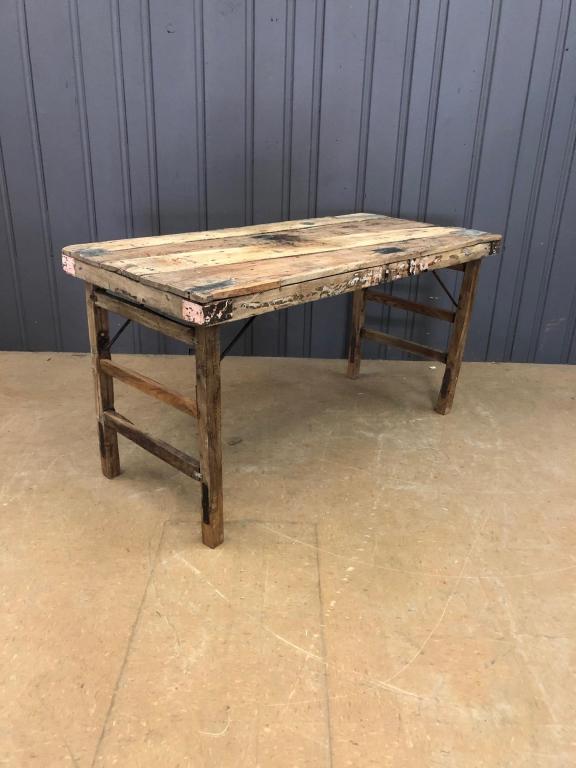 Rustic Folding Market Table: Rustic Folding Market Table. Heavy timber structure with spring steel brackets. Endearing zinc plate patches throughout. Sample photo. Size: 31.75" H x 58.75" W x 27.25" D. Due to the nature of the si