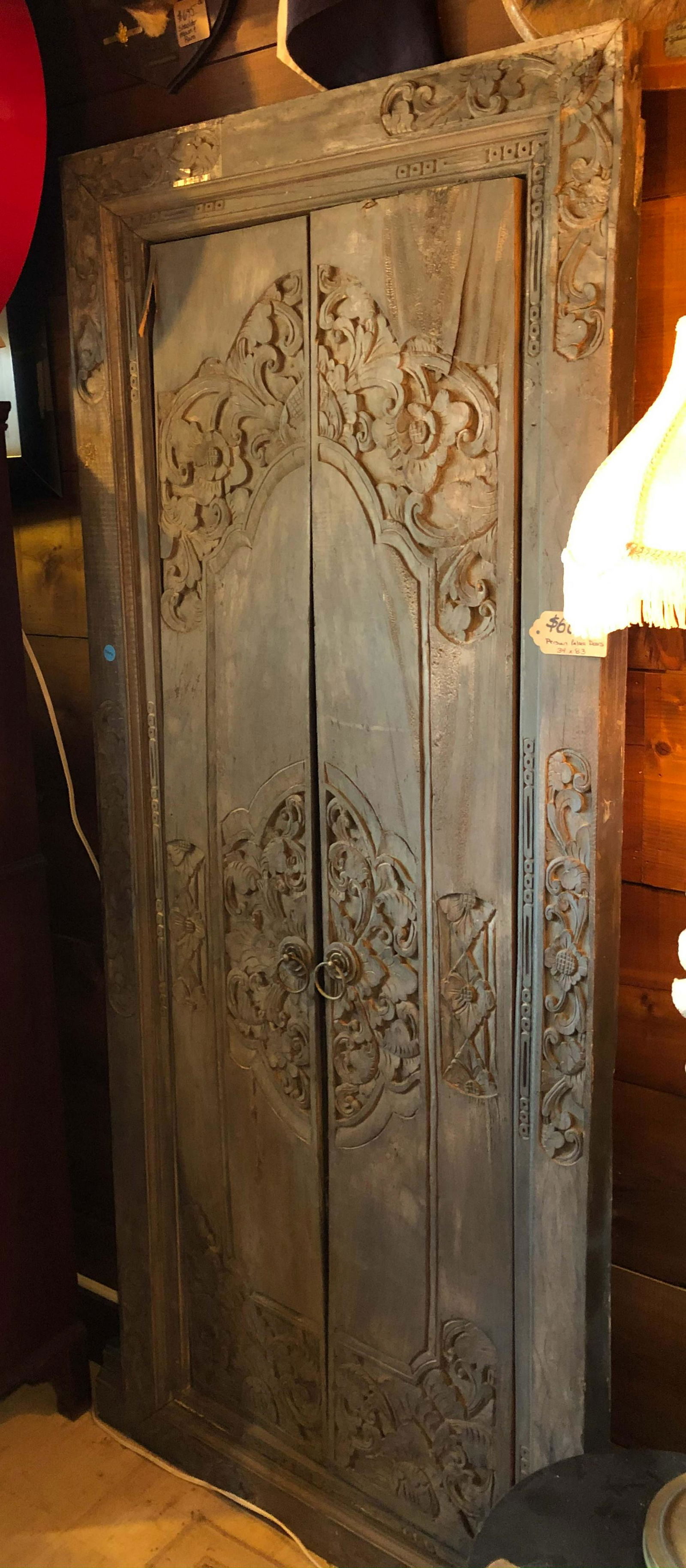 A Carved Indian Architectural Door: A Carved Indian Architectural Door having two doors with floral decoration. Size:52 1/2" x 34" x 2"