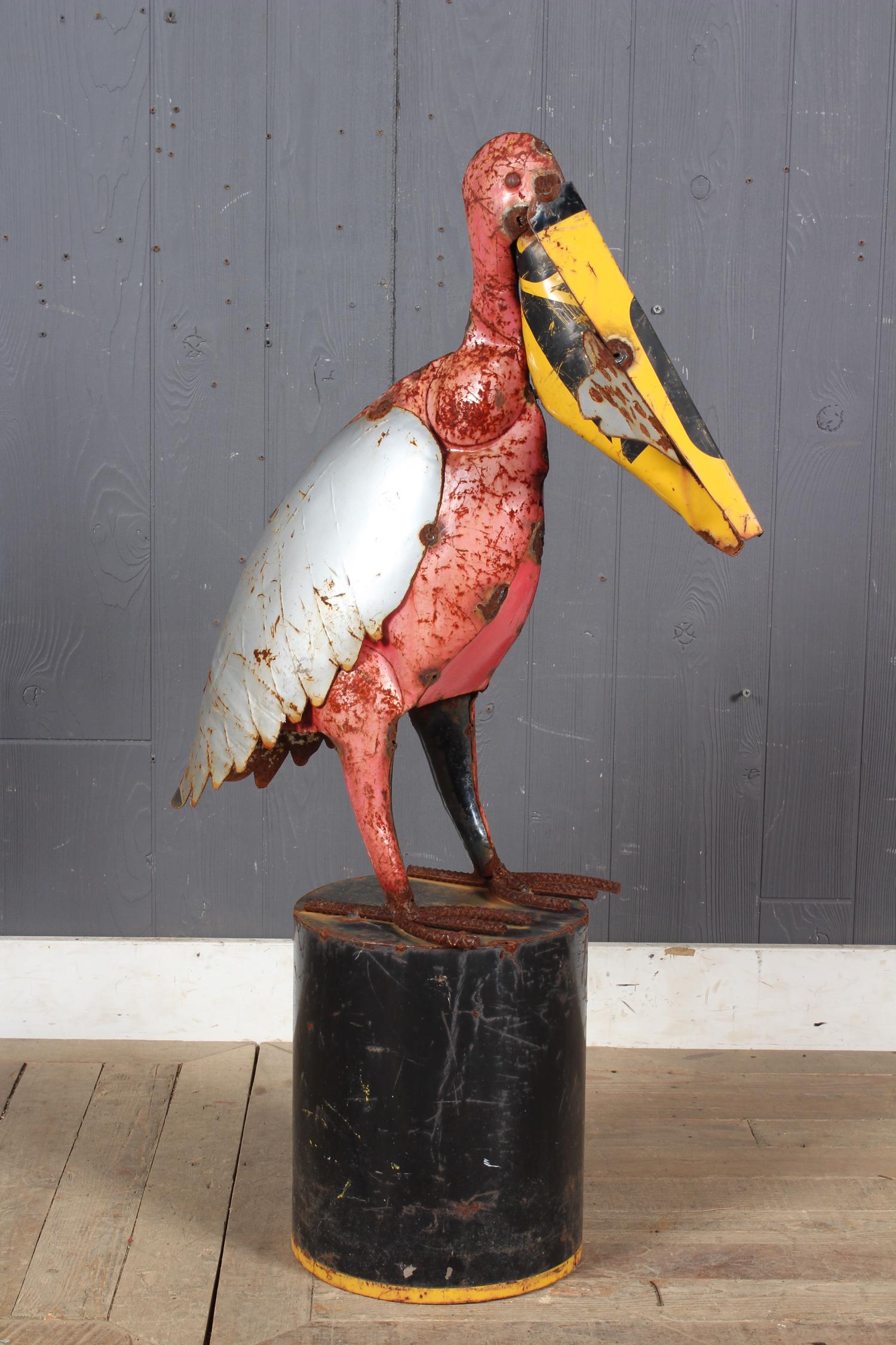 Folk Art Steel Pelican Garden Sculpture: An interesting folk art painted metal pelican resting on stump. Size: 36.5" H x 10" W x 22.5" D