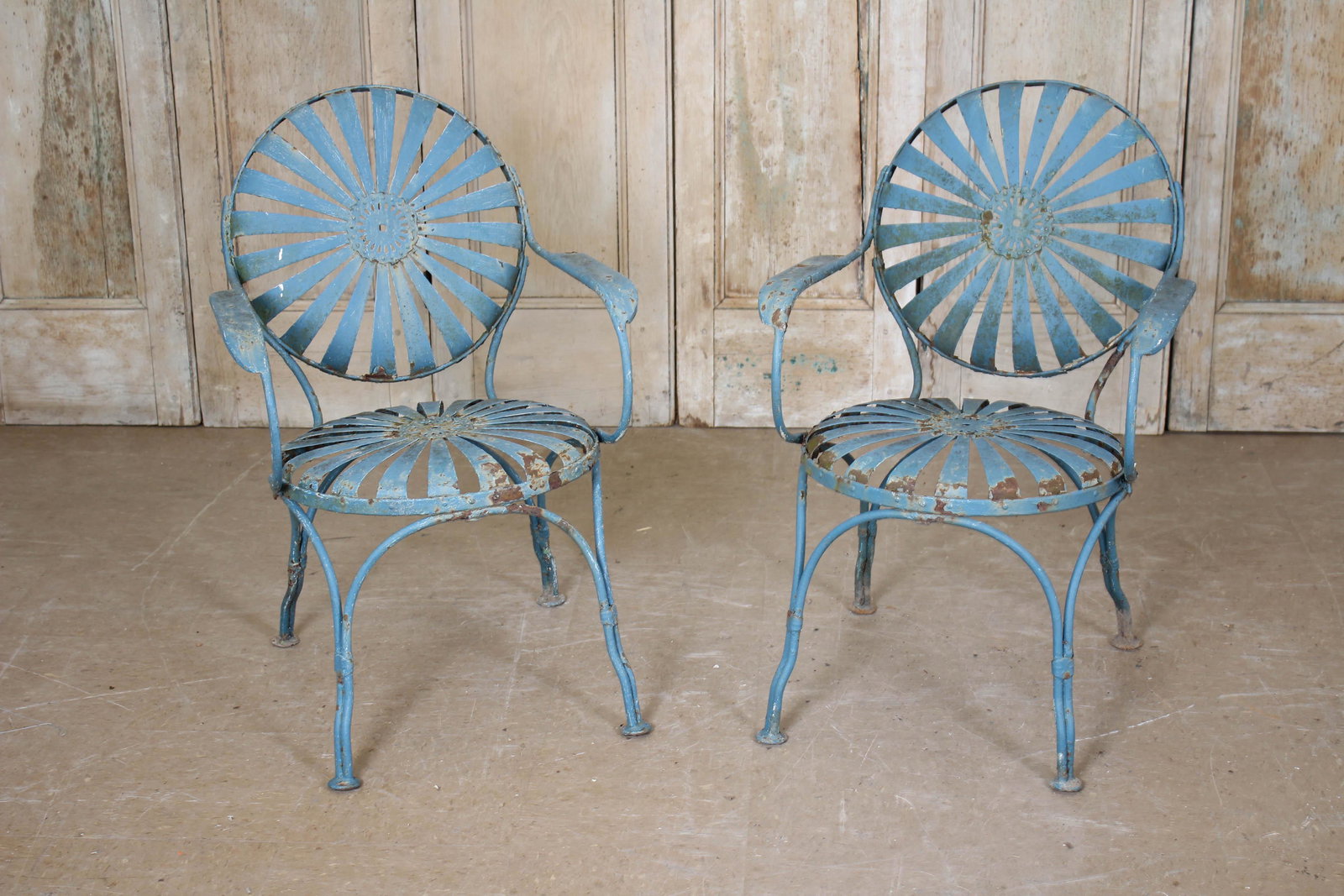Pair Francois Carre Style Garden Chairs: A vintage pair of French Francois Carre style spring seat and back sunburst garden chairs. Remnants of blue paint. 33" x 23" x 20"