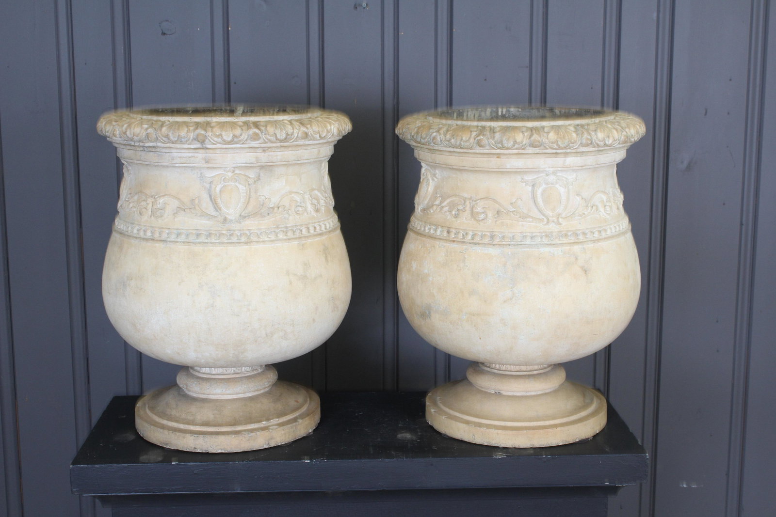 Antique 19th C Terracotta Garden Urns: A very good pair of 19th century French/ Italian terracotta garden urns having gadrooned rim over scroll and foliate decoration all raised on a stepped base. Size: 22" H x 17" Diameter.