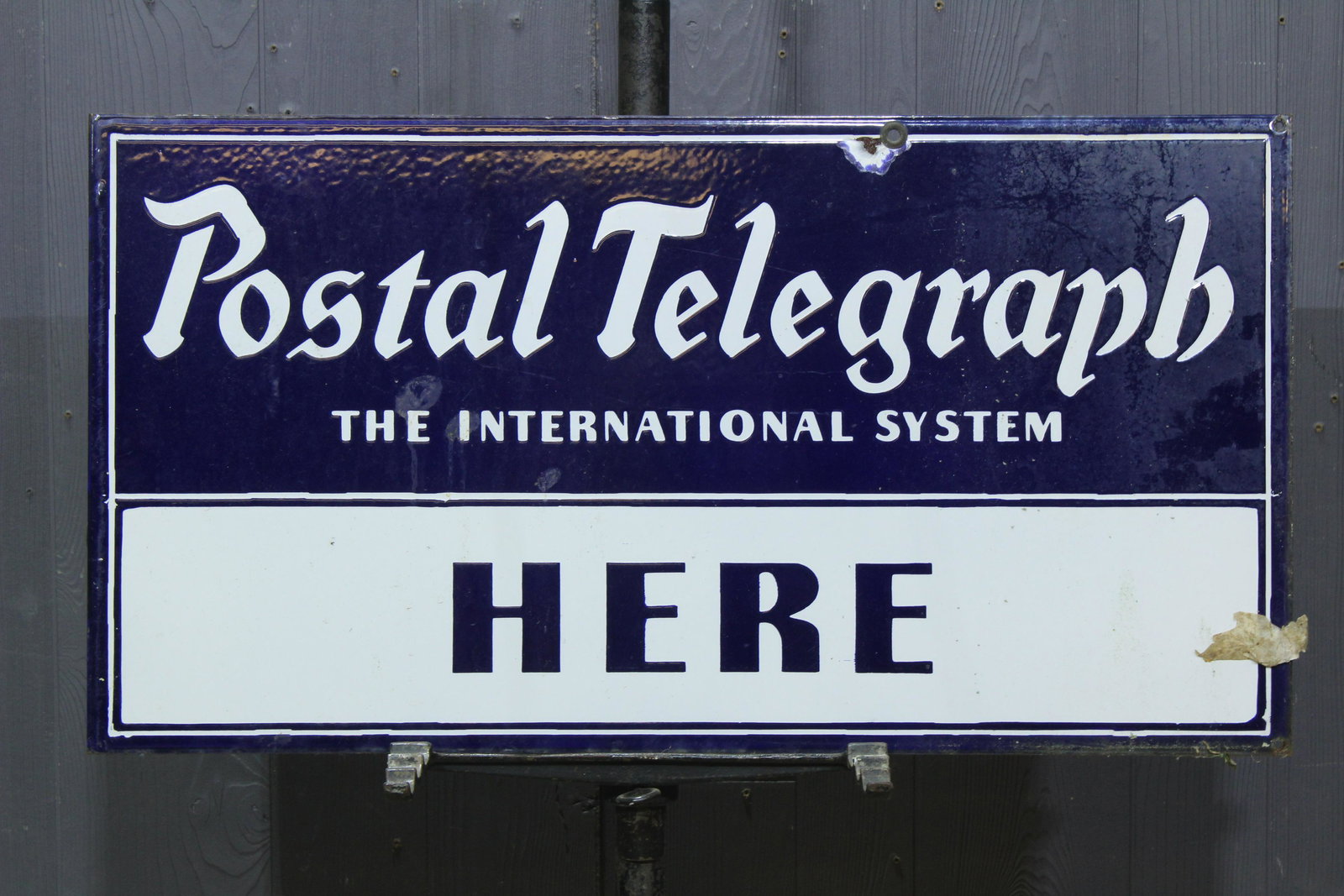 Postal Telegraph Porcelain 2 Sided Flange Sign: Postal Telegraph Porcelain 2 Sided Flange Sign, double sided iron sign, "Postal Telegraph The International System, Here", marked Tennessee Enamel Mfg. Co. Nashville. Size: 16.5" H x 30" W x 2.75" D.