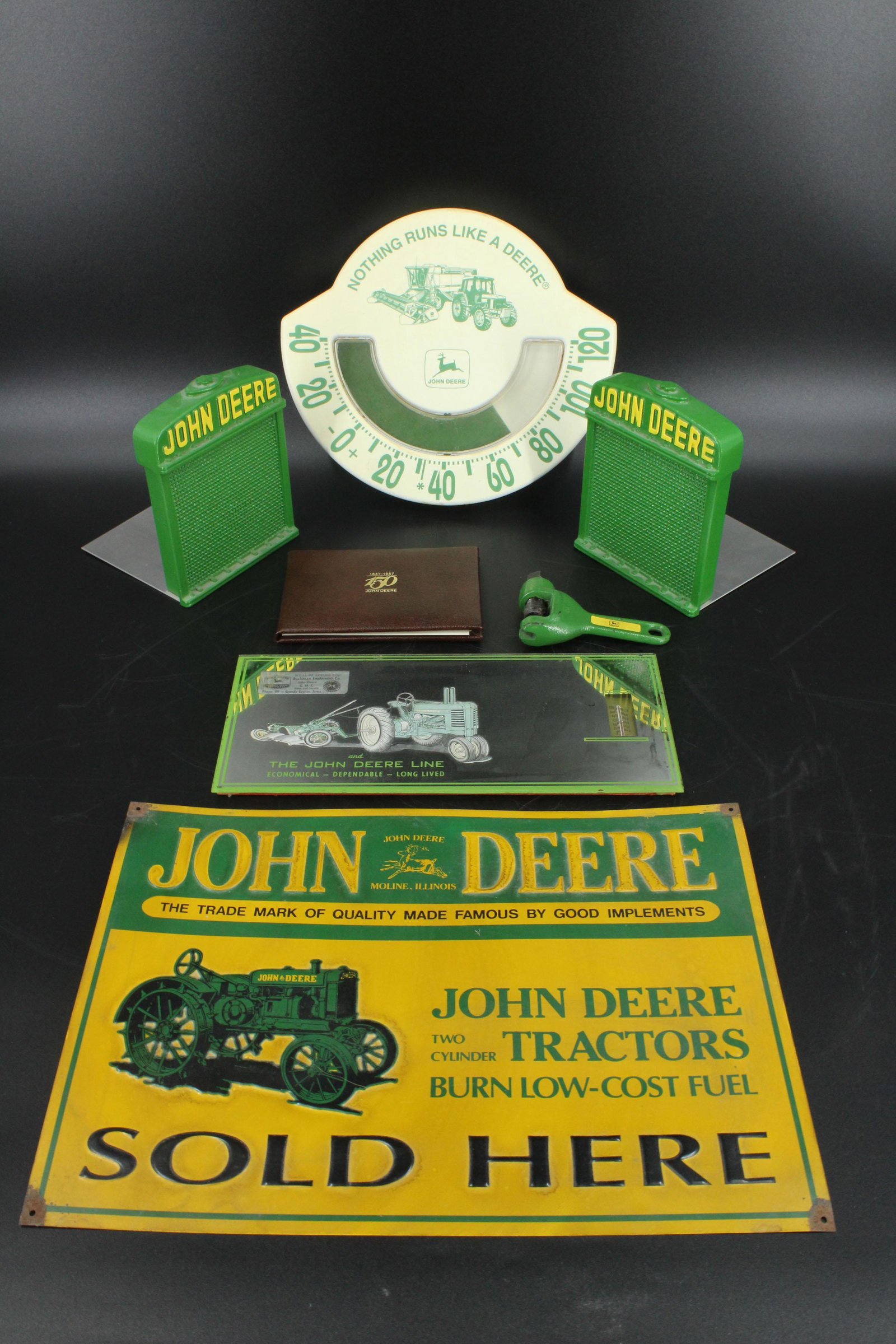 Grouping of John Deere Memorabilia: Grouping of John Deere Memorabilia, includes Nothing Runs Like a Deere thermometer by Chaney Instrument Co., miniature clamp with Deere logo on side, pair of bookends, mirrored thermometer advertiseme