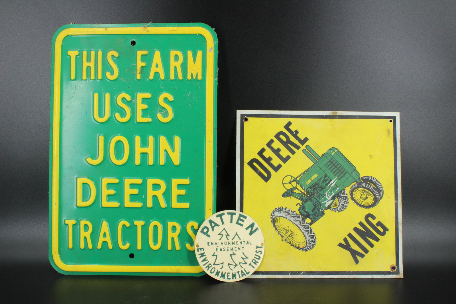 2 Deere Signs and Environmental Trust Sign: 2 Deere Signs and Environmental Trust Sign, includes Deere Xing Tractor tin sign, This Farm Uses John Deere Tractors porcelain on iron sign, and a Patten Environmental Trust Environmental Easement tin