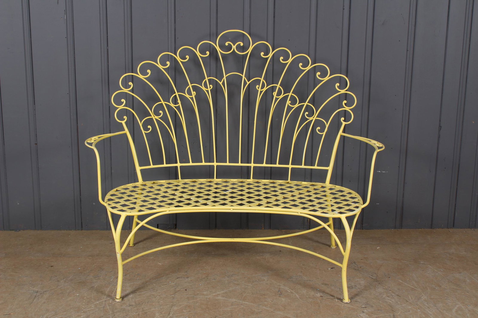 Wrought Iron Scroll Fan Back Settee: A very interesting vintage wrought iron garden bench having scrolling shell form back over trellis seat. 46" H x 56.5" W x 31" D