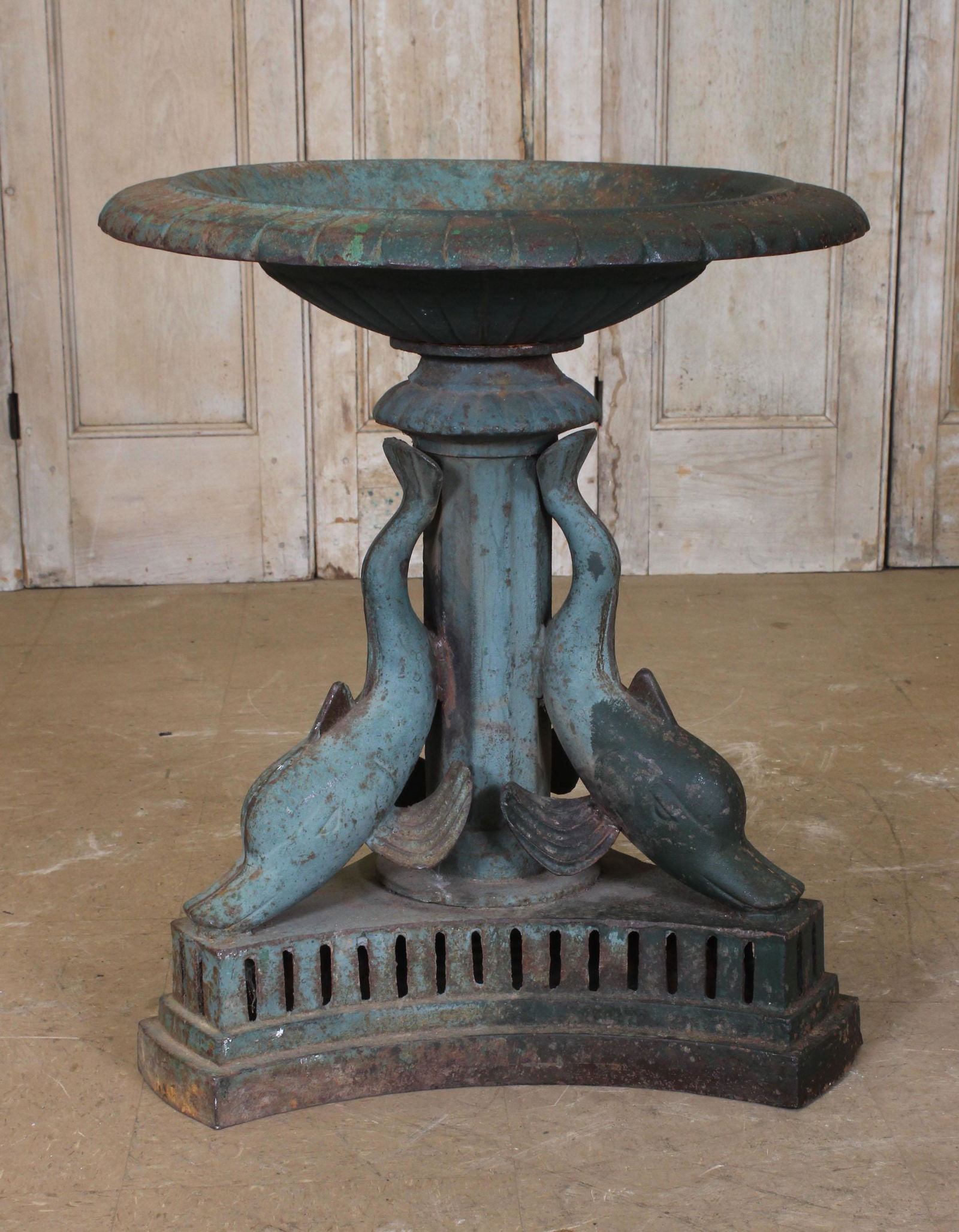 Cast Iron Dolphin Fountain Basin: A vintage cast iron fountain having gadroon bowl supported on dolphin decorated base all raised on stepped base. Size: 29" H x 24.5" diameter.