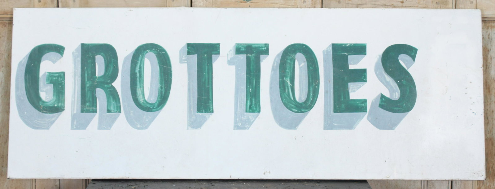 Grottoes Sign: A vintage tin painted Grottoes sign. Size: 24.5" H x 66" W x 1.5" D