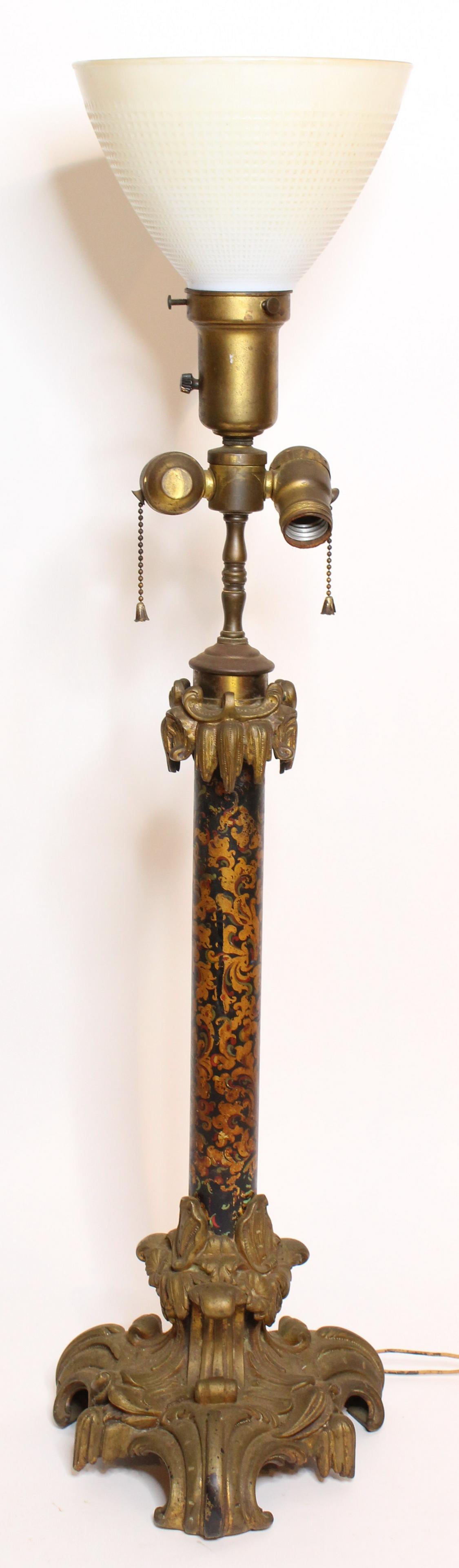 Bronze and Tole Painted Table Lamp: Bronze and Tole Painted Table Lamp, double socket, glass shade, scroll design, bronze footed base. Size: 35" H x 8.5" W x 9.5" D ***Please Note: This is an on-site online auction with specific Pick up