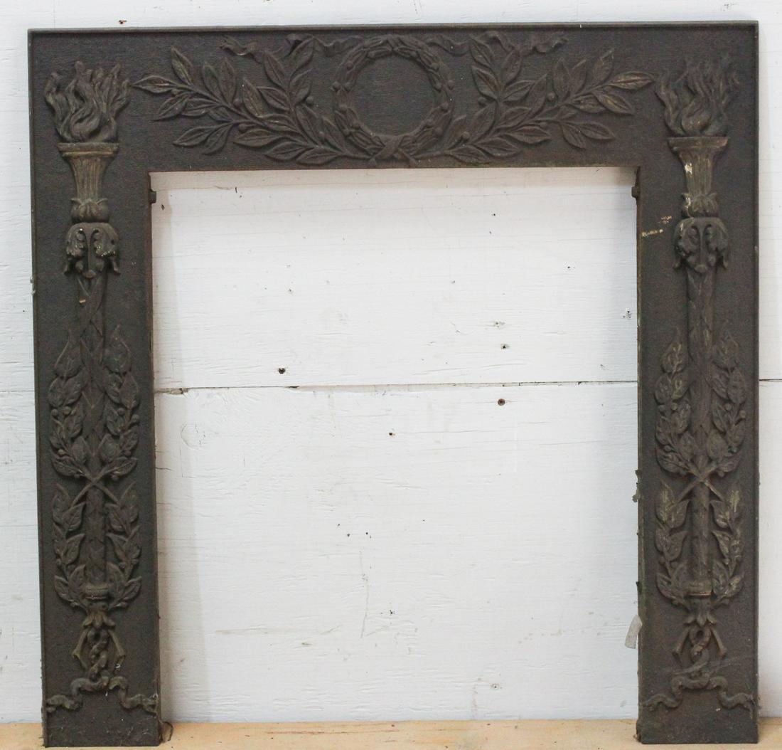 Cast Iron Hearth Surround: Cast iron hearth surround laurel wreath and torch motif. Size: 30.5"H x 30"W ***Please Note: This is an on-site online auction with specific Pick up terms and conditions. Pick up day is scheduled for 