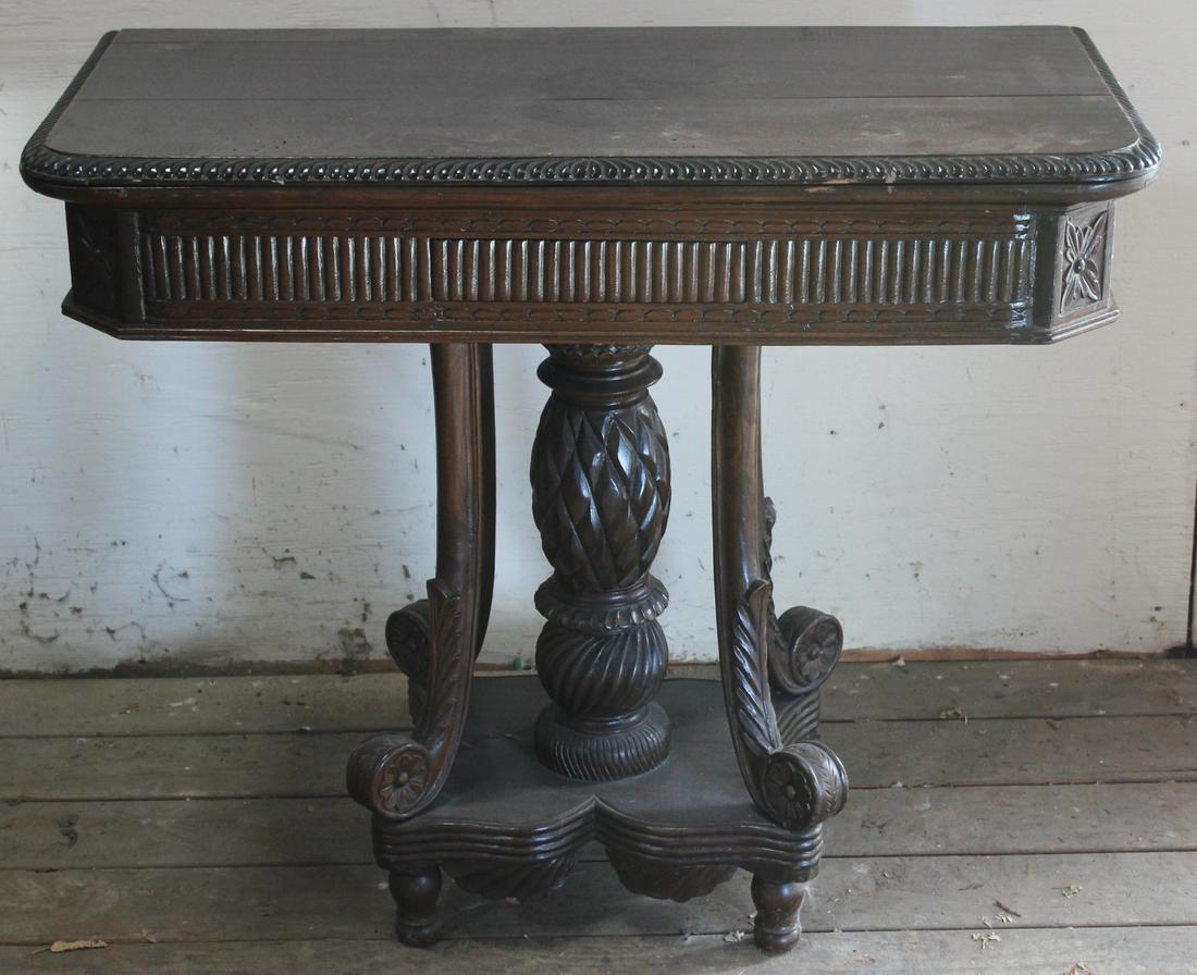 Transitional Carved mahogany Flip Top Table: A transitional carved mahogany flip top card table having central pineapple and scroll carved decoration. Size: 32"H x 37"W x 18"D ***Please Note: This is an on-site online auction with specific Pick 