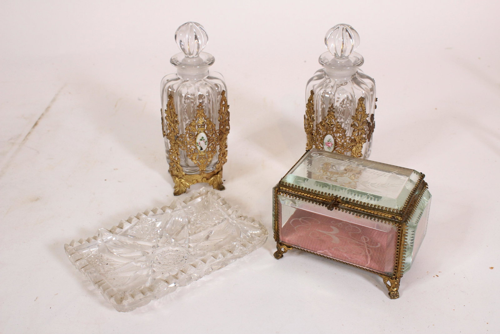 Lot of Glass Dresser Accessories: Lot of Dressing Accessories. Including 2 French filigree mounted perfume bottles, souvenir dresser box etched " From Washington", and a cut glass pen tray. Size: largest 6.5" high. ***Please Note: Thi