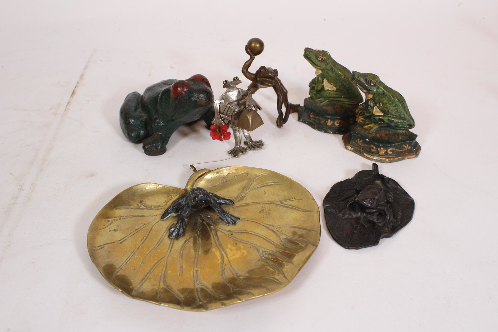 Group of Frog Bibelots: Group of Frog Bibelots. Copper, cast iron, and bronze. Size: largest 6.75" x 7.75" x 2" ***Please Note: This is an on-site online auction with specific Pick up terms and conditions. Pick up day is sch