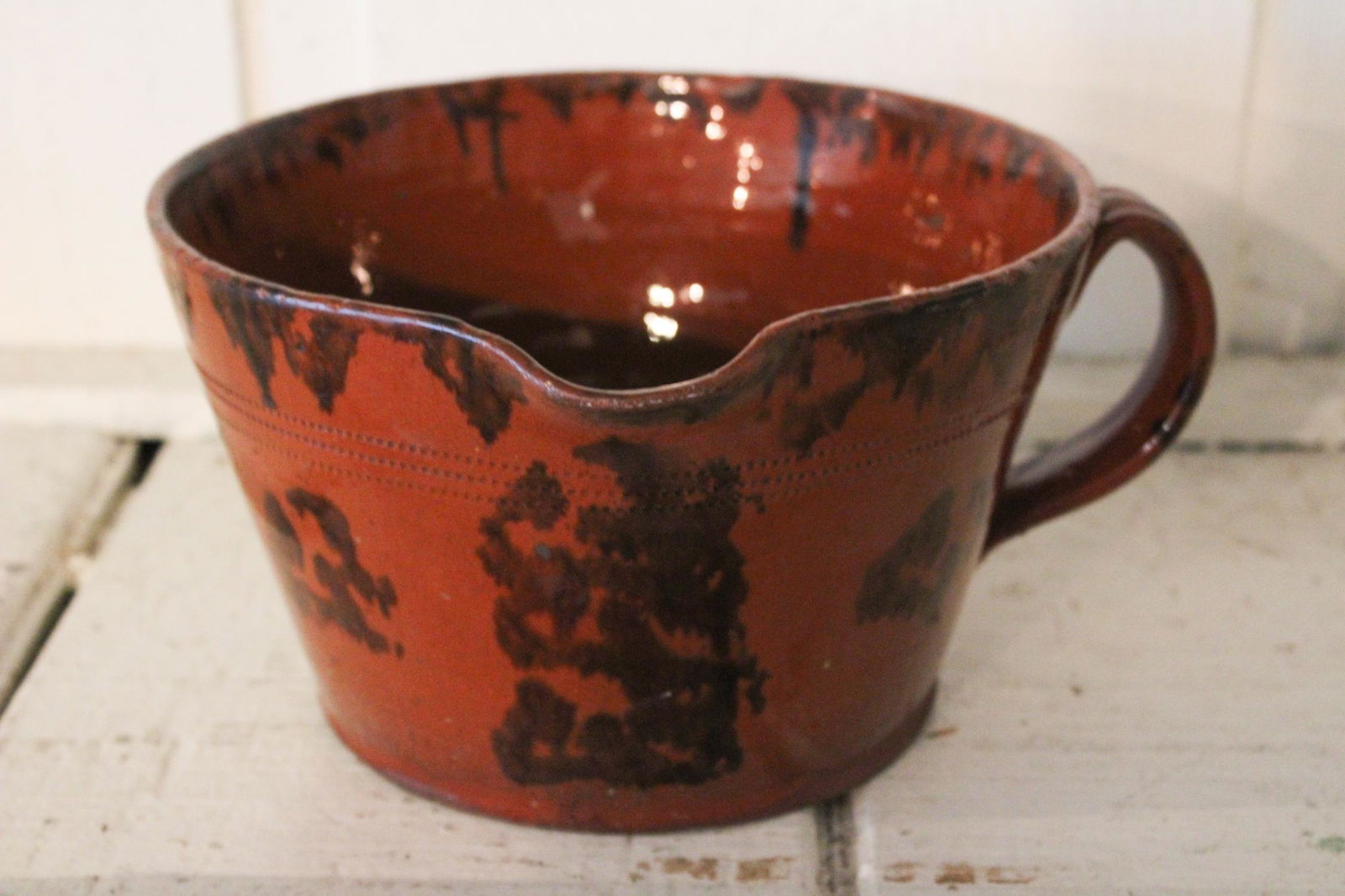 Antique Redware Handled Milk Pitcher: Antique Redware Handled Milk Pitcher. Manganese decoration. Size: 5" x 8.75" x 9.5" ***Please Note: This is an on-site online auction with specific Pick up terms and conditions. Pick up day is schedul