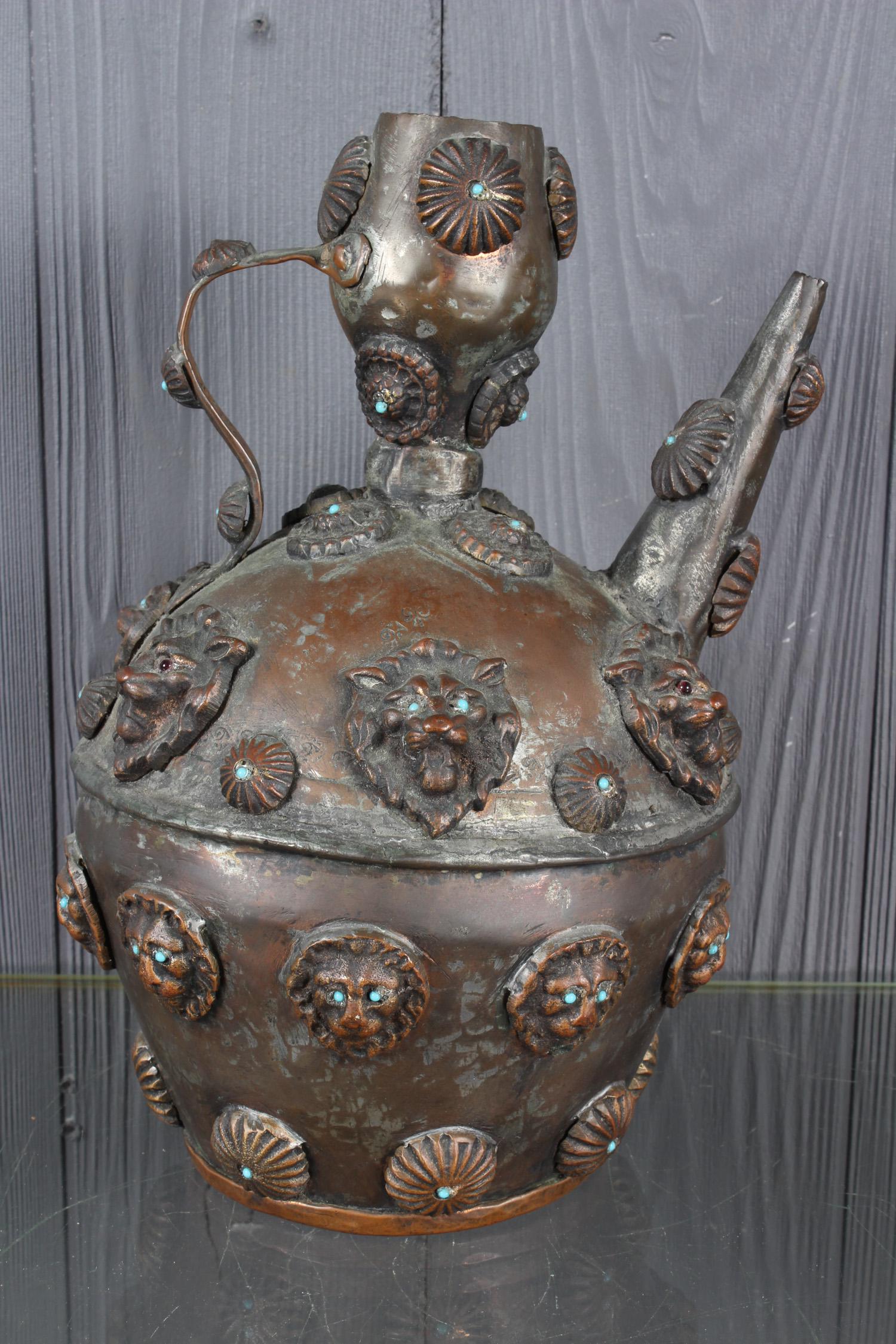 Lion Head Copper Ewer: Lion Head Copper Ewer, applied lion head mask and roundel decoration with turquoise and garnet colored stones. Size: 12" H x 7.5" W x 7" D
